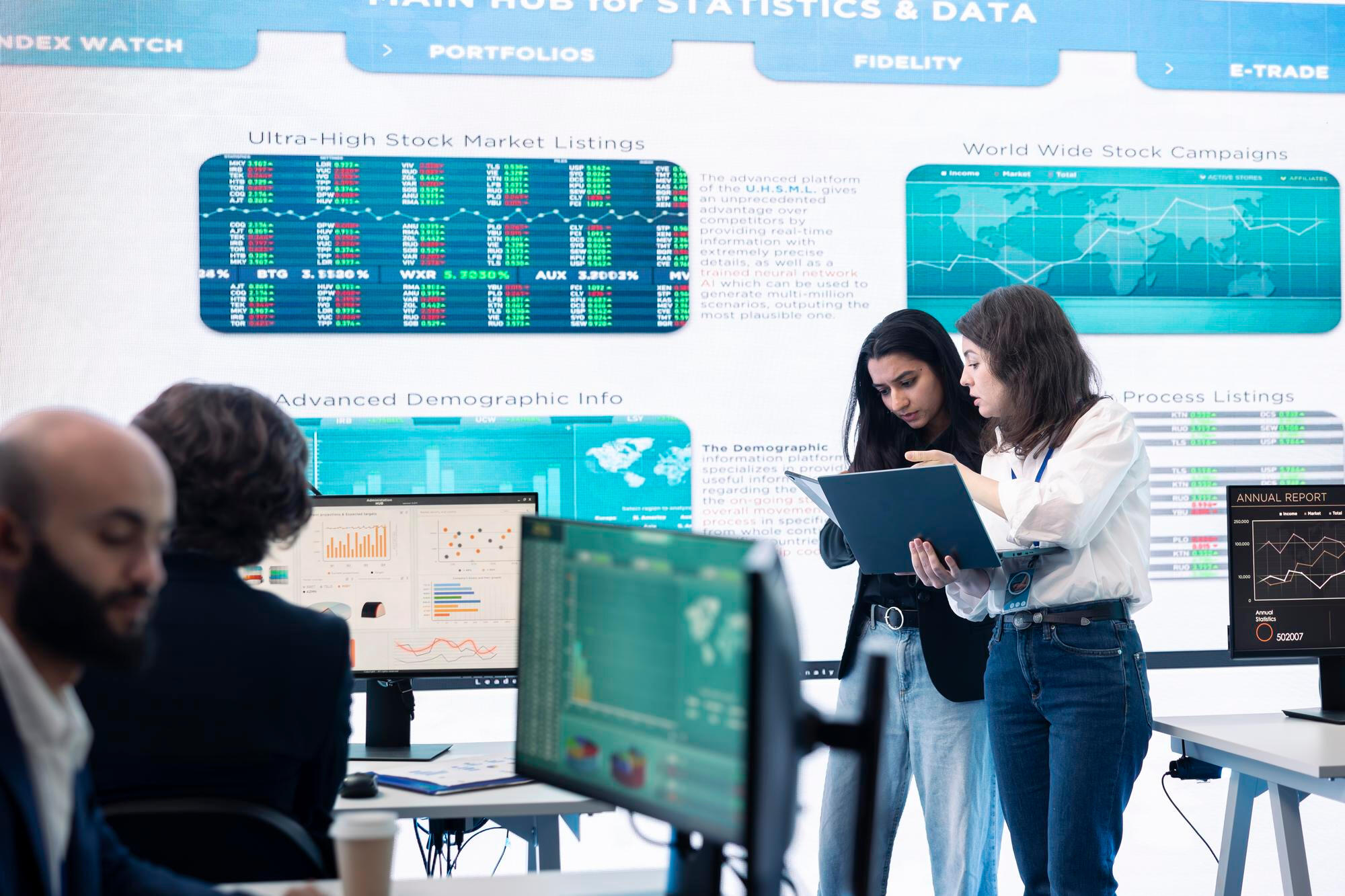 A diverse group of individuals gathered around a computer screen, engaged in discussion and collaboration.