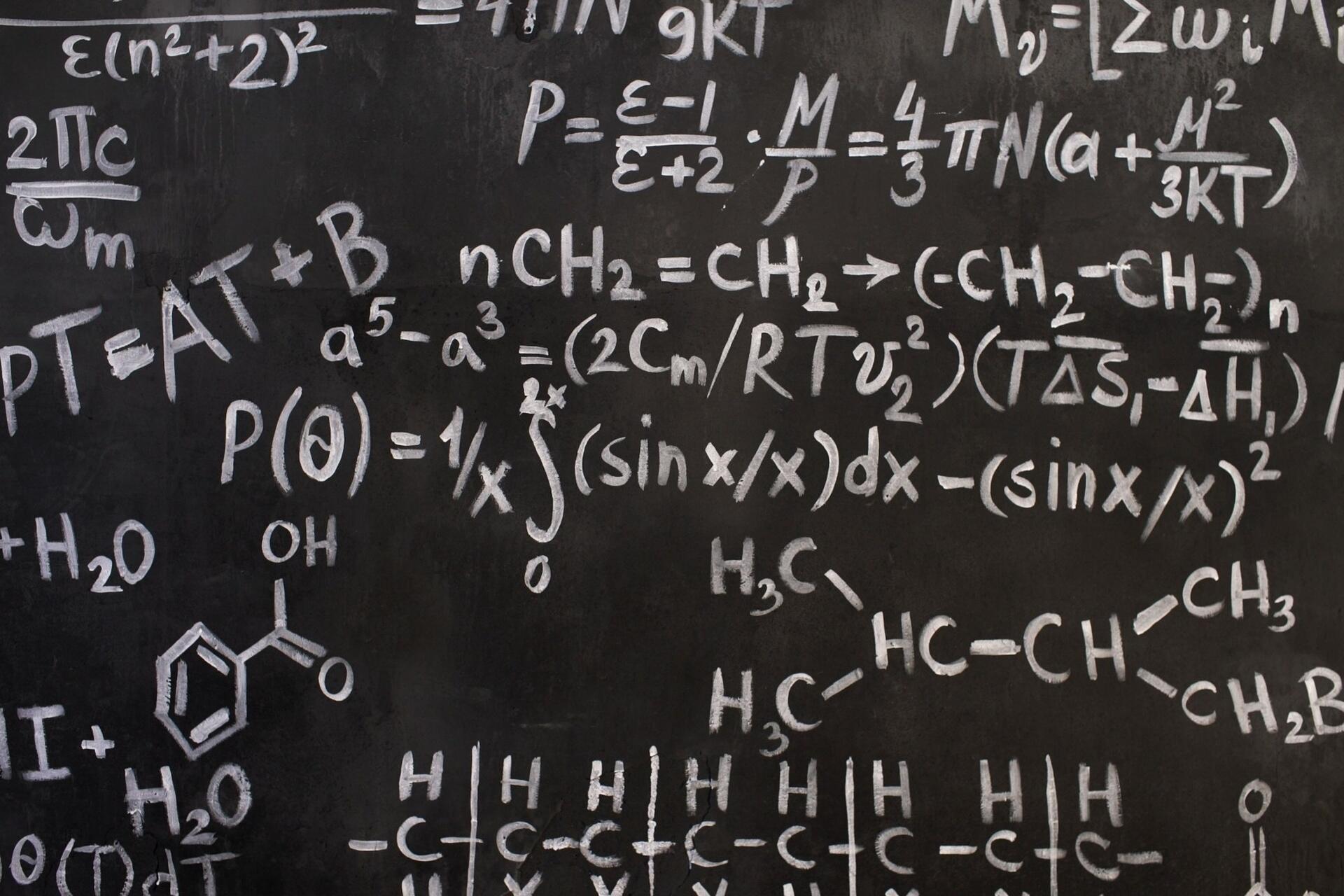 Advanced mathematical formulas and equations written on a blackboard representing H2 Math Singapore concepts and A-Level mathematics preparation.