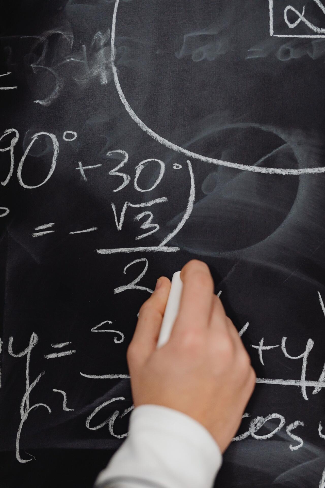Student writing algebraic expressions on a whiteboard while preparing for the H2 Mathematics Singapore A-Level examination.