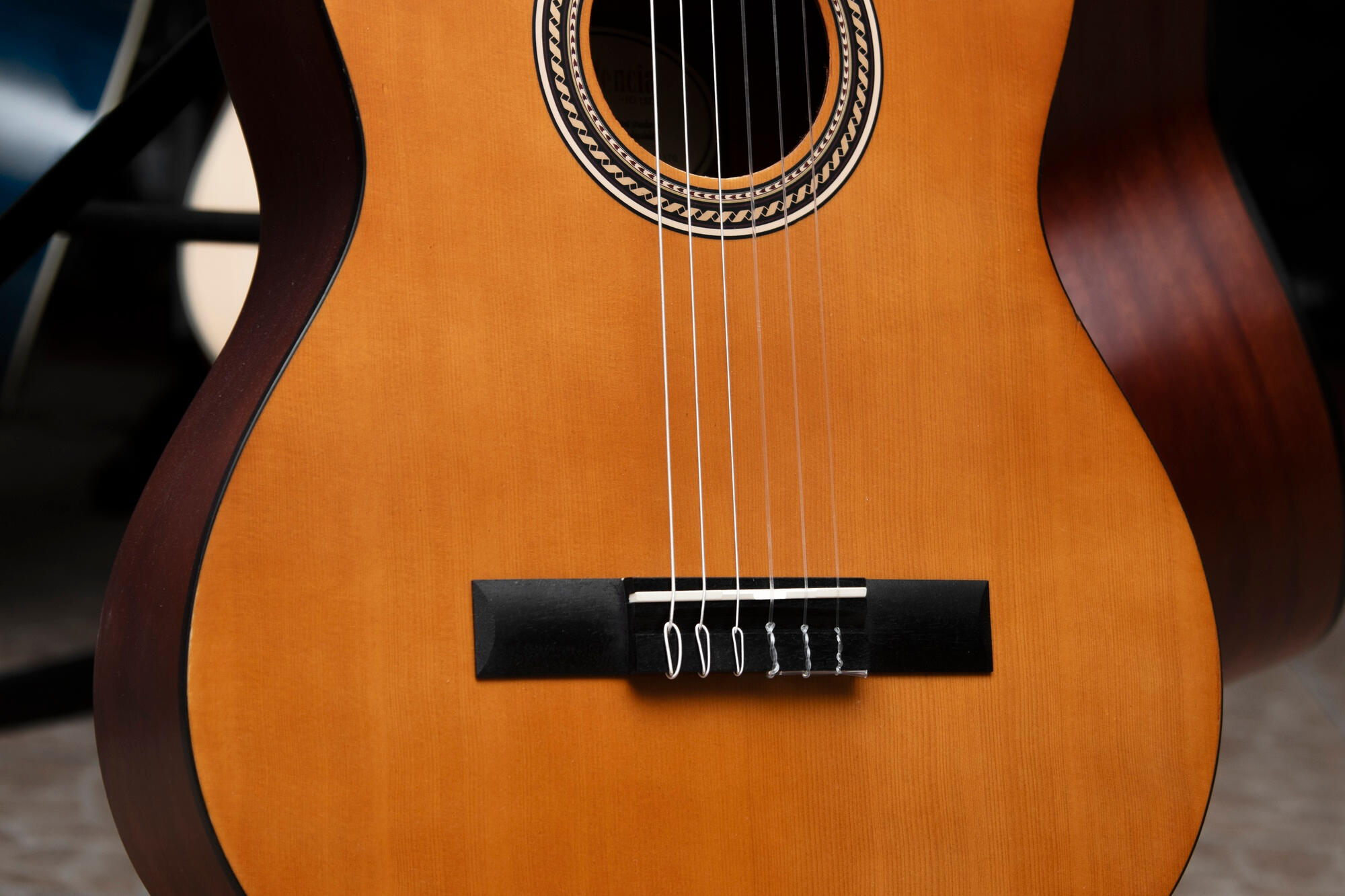 A guitar resting on a stand, showcasing its body and neck in a well-lit environment.
