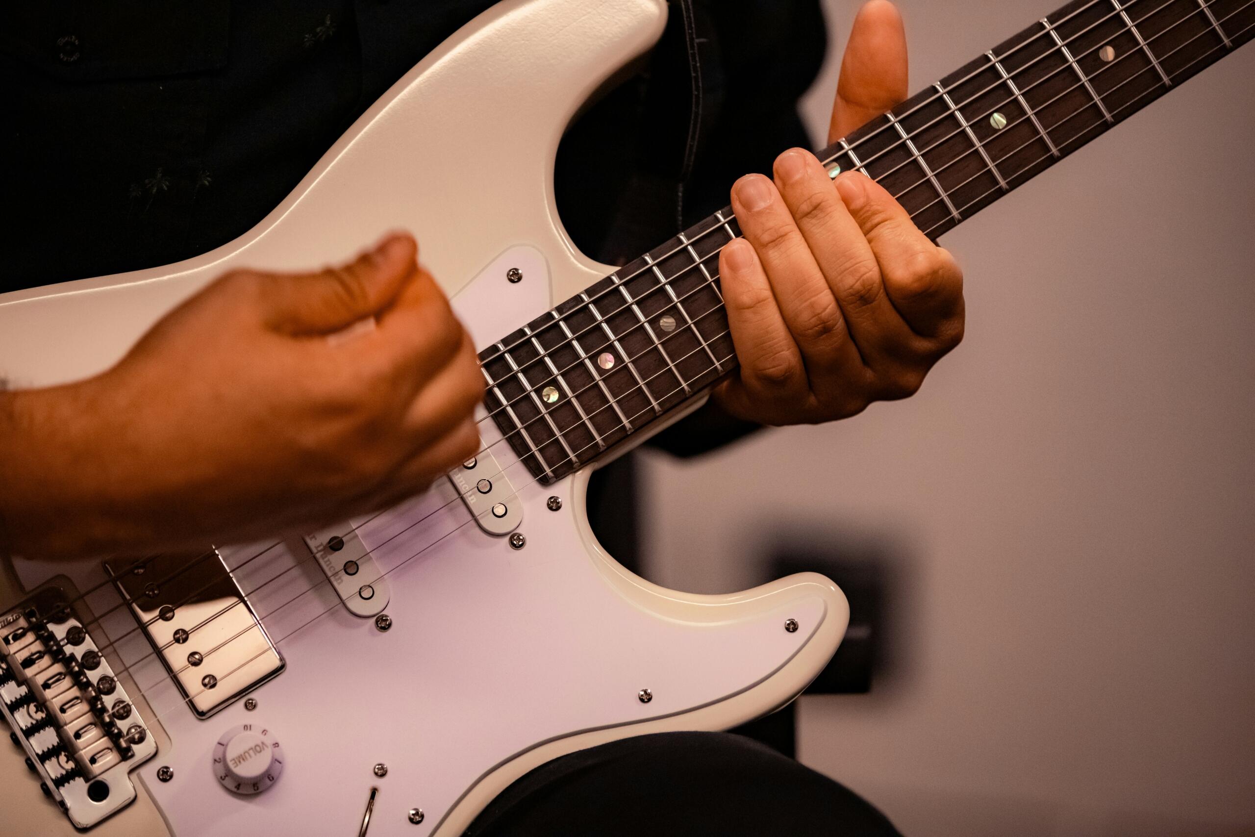A musician performing with an electric guitar, showcasing skill and energy in a lively concert setting.