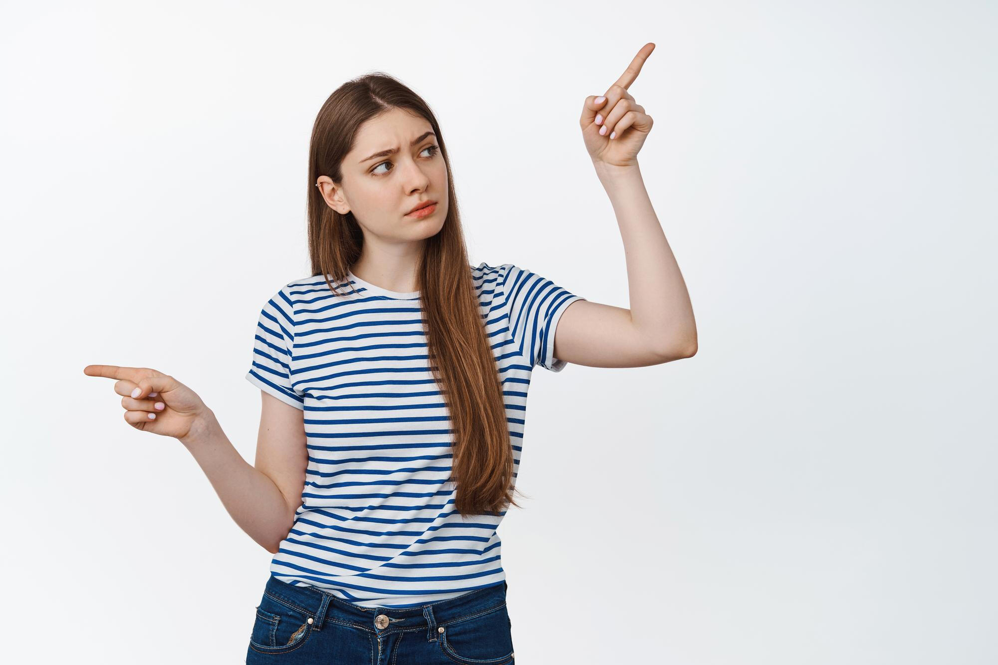 A woman in a striped shirt points towards an unseen object, displaying curiosity or emphasis in her gesture.