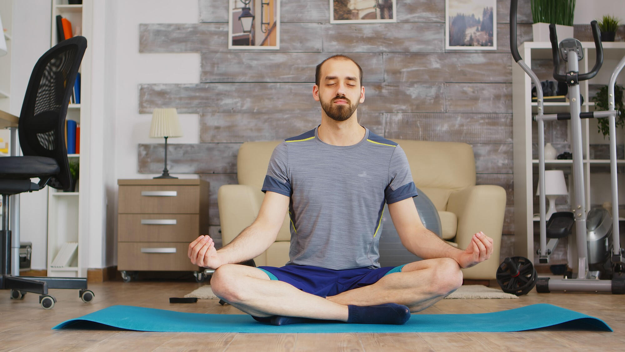 A man in a yoga pose sits cross-legged, embodying calmness and mindfulness in a peaceful setting.