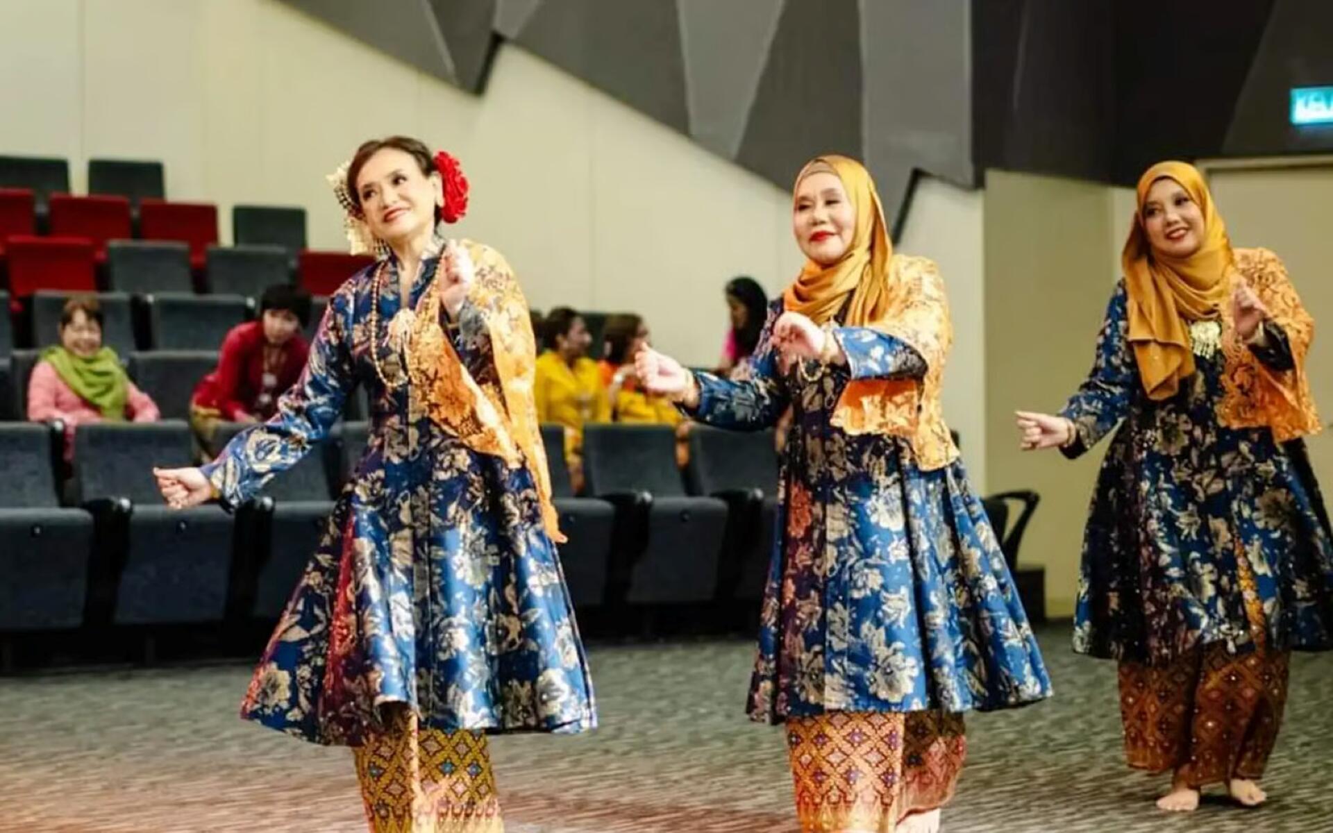 Three women in colorful traditional dresses perform a lively dance, showcasing cultural heritage and artistry.
