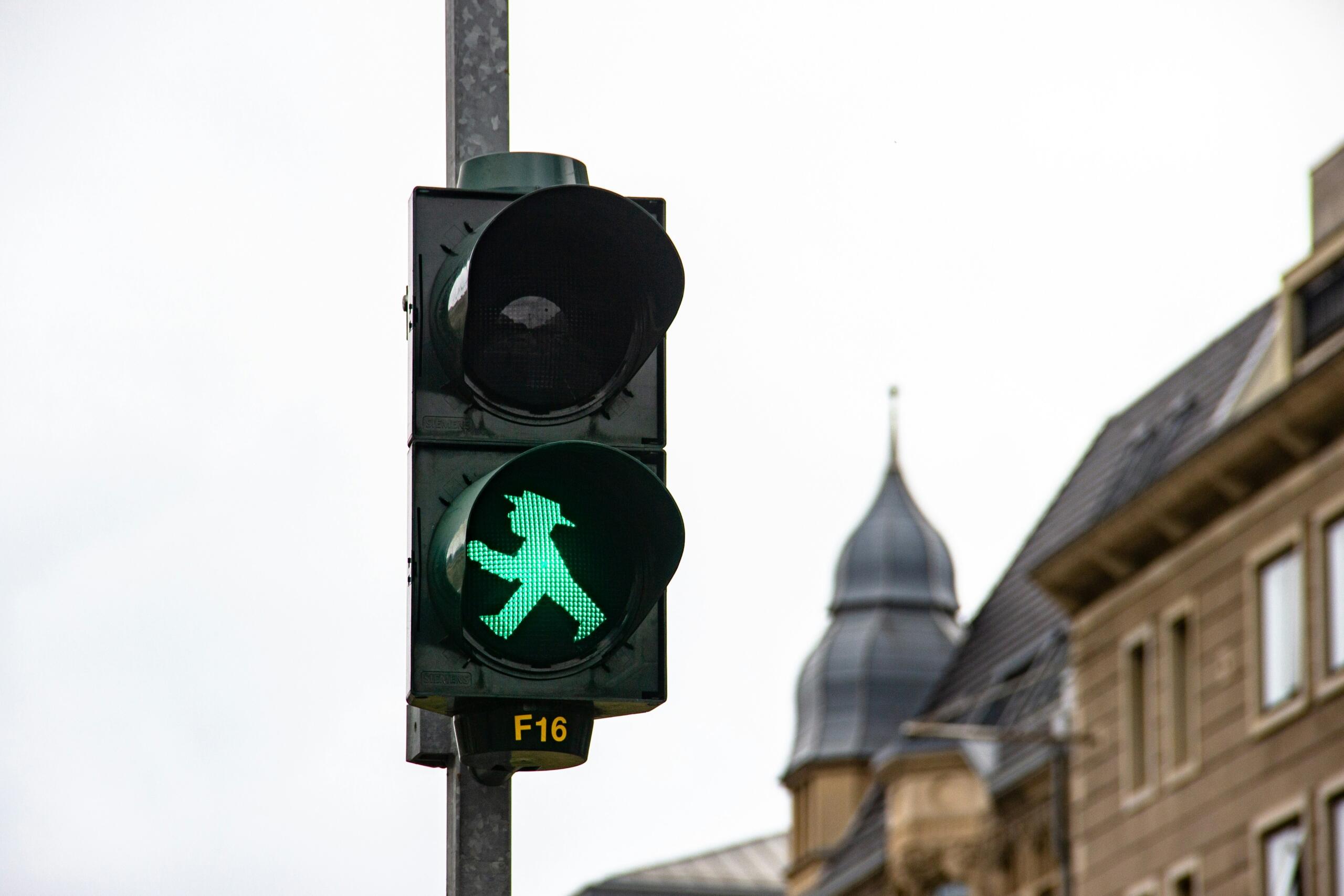zeleni semafor s figurico Ampelmännchen v mestnem okolju v Nemčiji