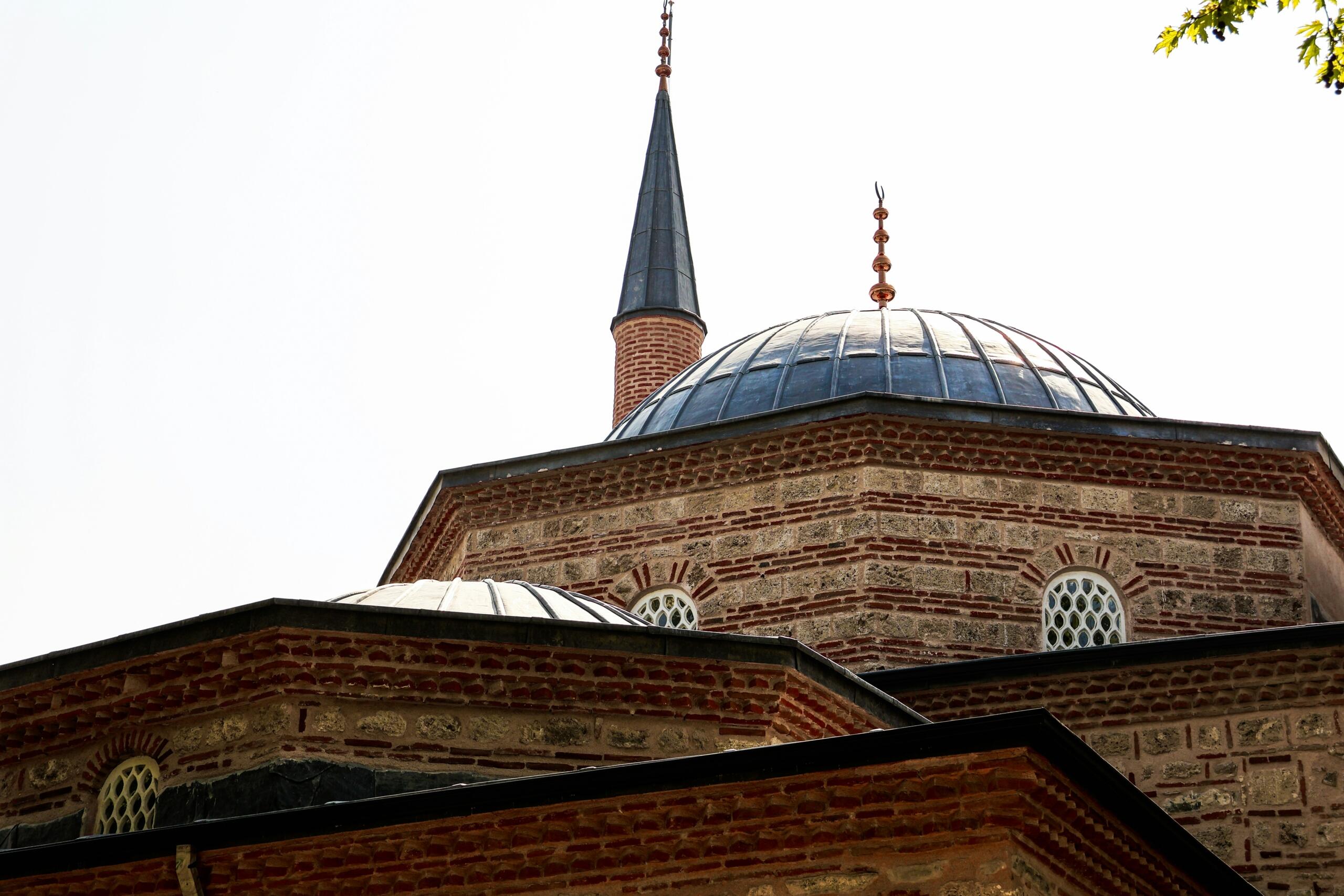 kupole in minaret osmanske mošeje z značilno opečno in kamnito fasado