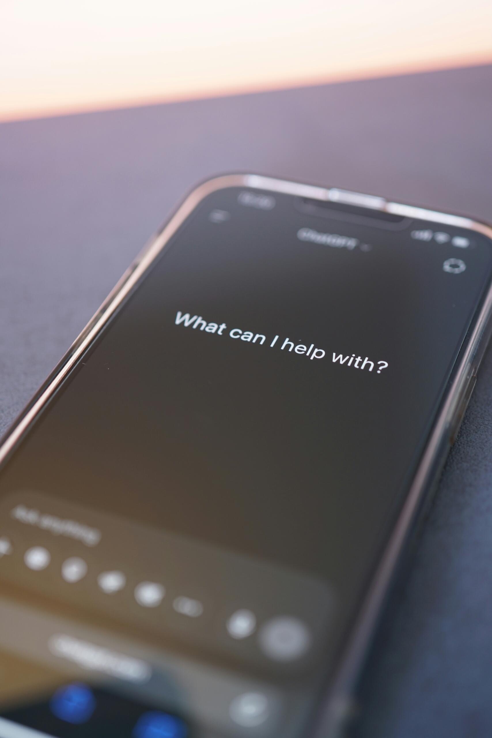 Pametni telefon z zaslonom, ki prikazuje sporočilo 'What can I help with?' v klepetalni aplikaciji
