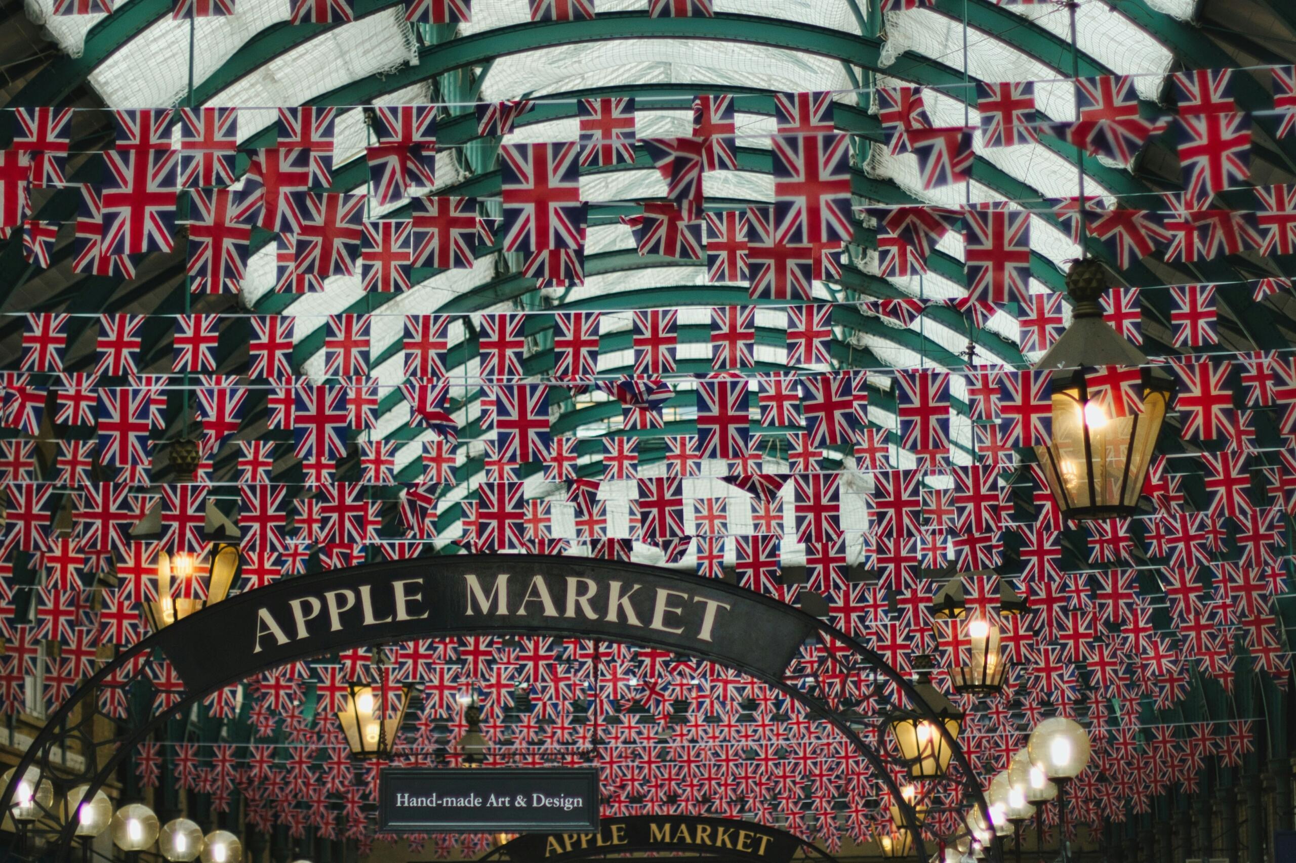 Notranjost Apple Marketa na Covent Gardenu v Londonu, okrašena s tisoči britanskih zastav Union Jack, ki visijo s steklene viktorijanske strehe