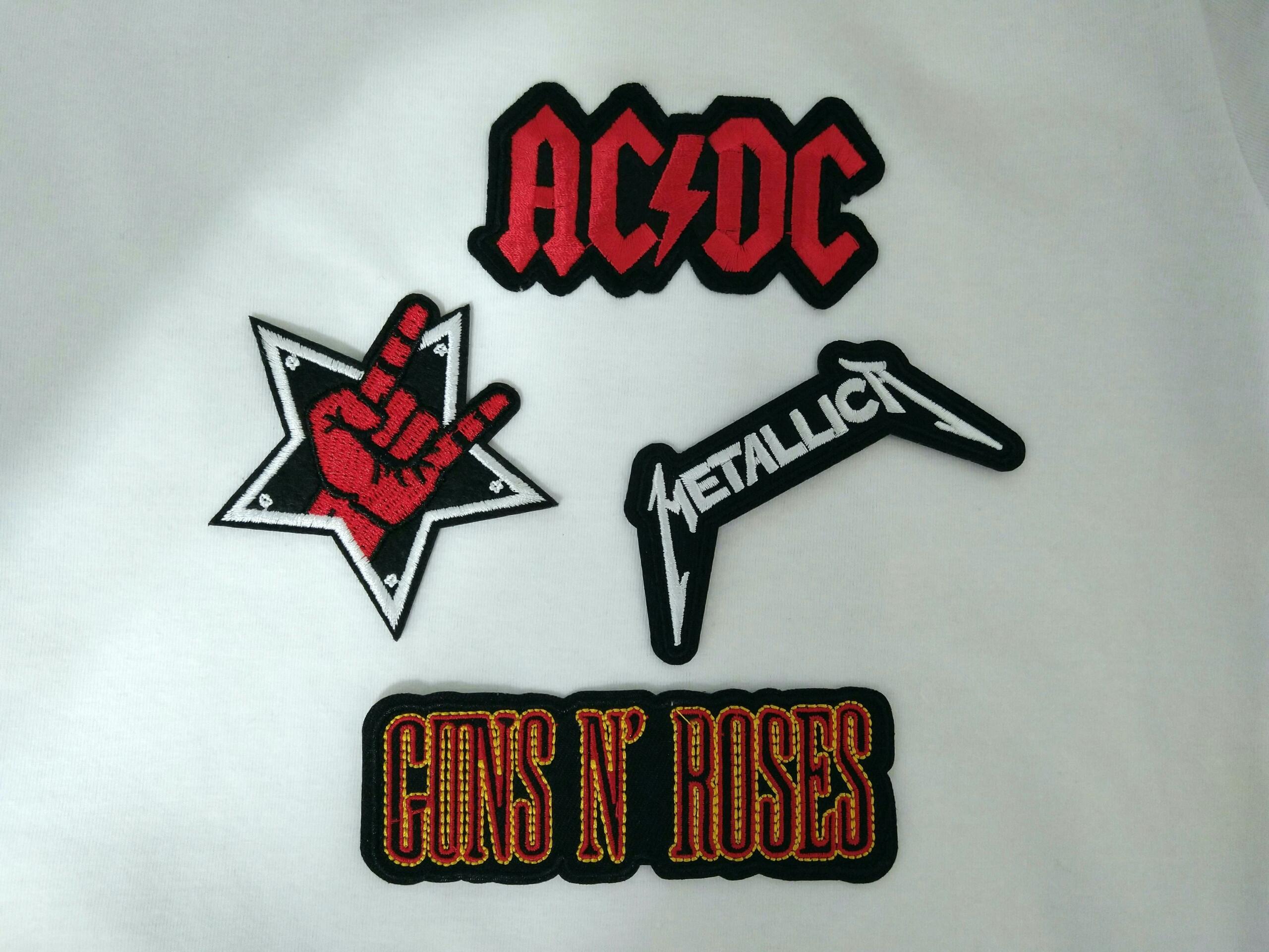Različni vezeni rock patch-i (AC/DC, Metallica, Guns N' Roses, rock roka) пришiti na belo majico, z rdečimi in črnimi detajli