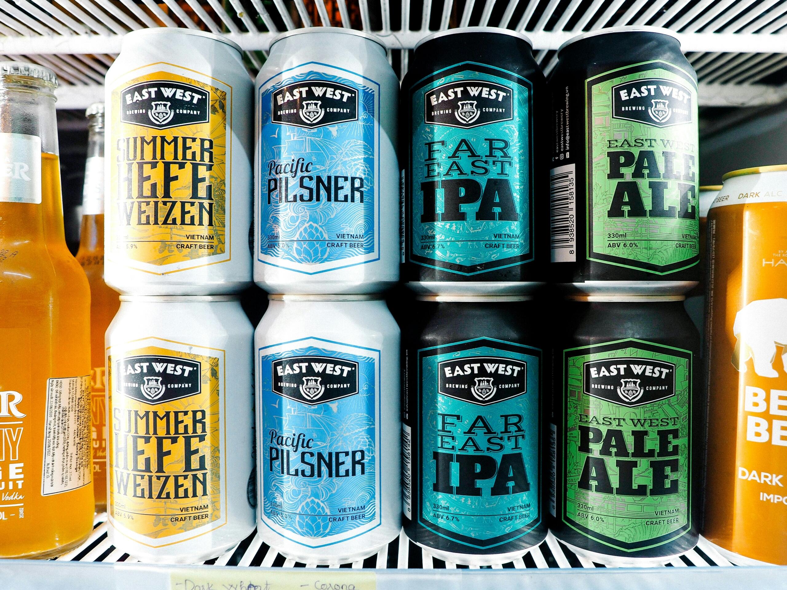 Različne pločevinke craft piva na polici v hladilniku