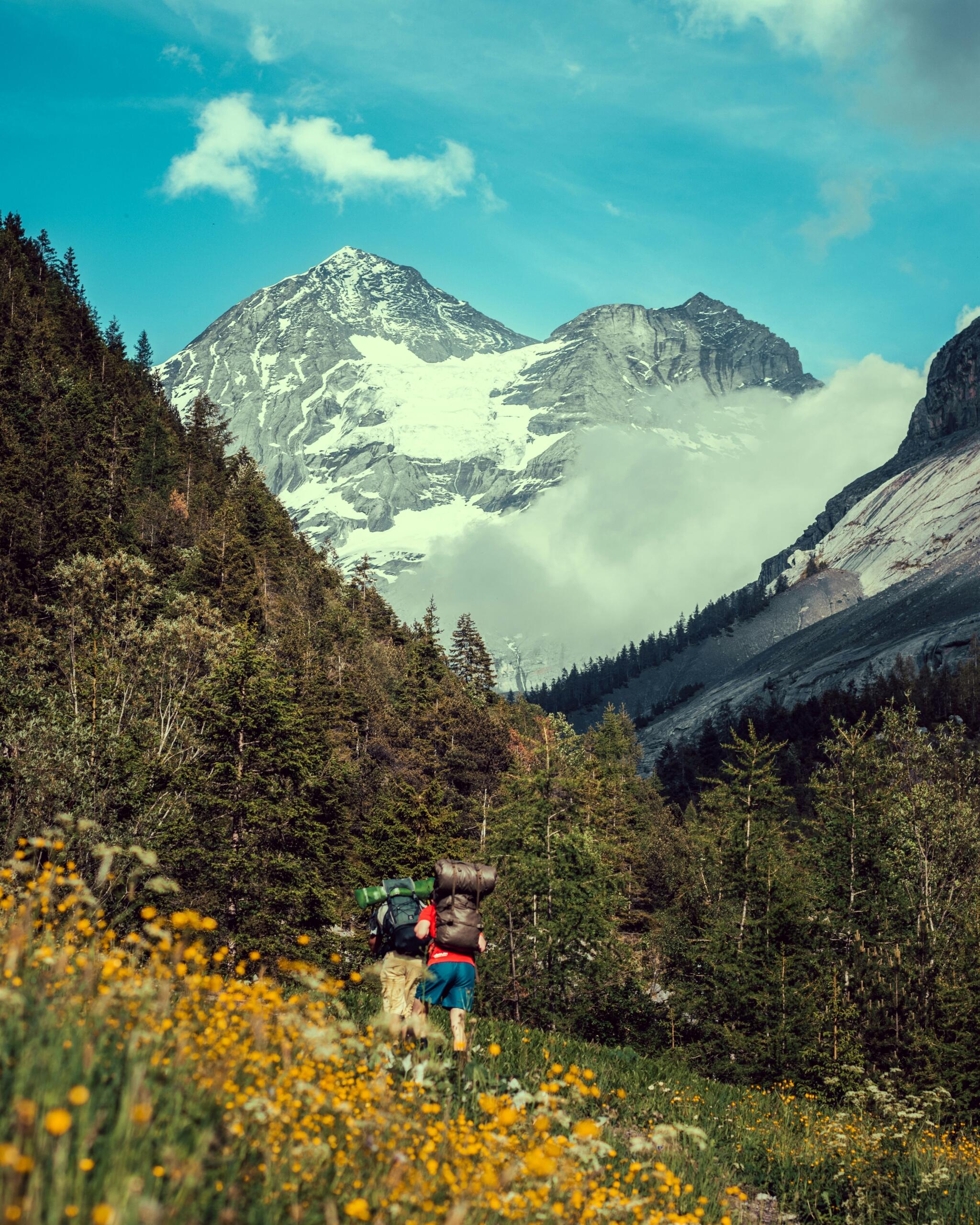 Pohodnika v gorah s pogledom na zasnežene vrhove