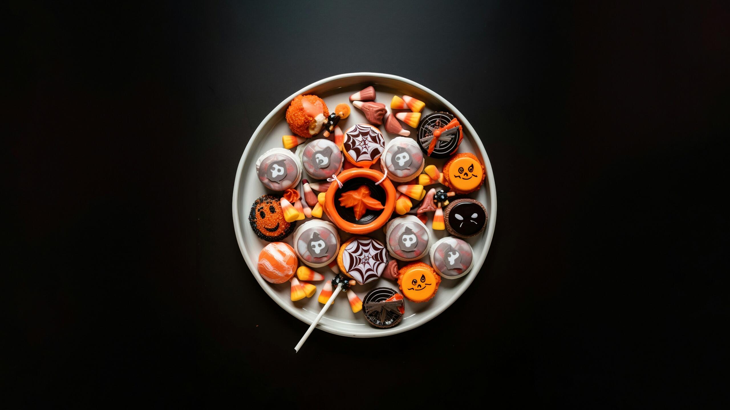 Krožnik s halloween sladkarijami in pisanimi jesenskimi motivi.