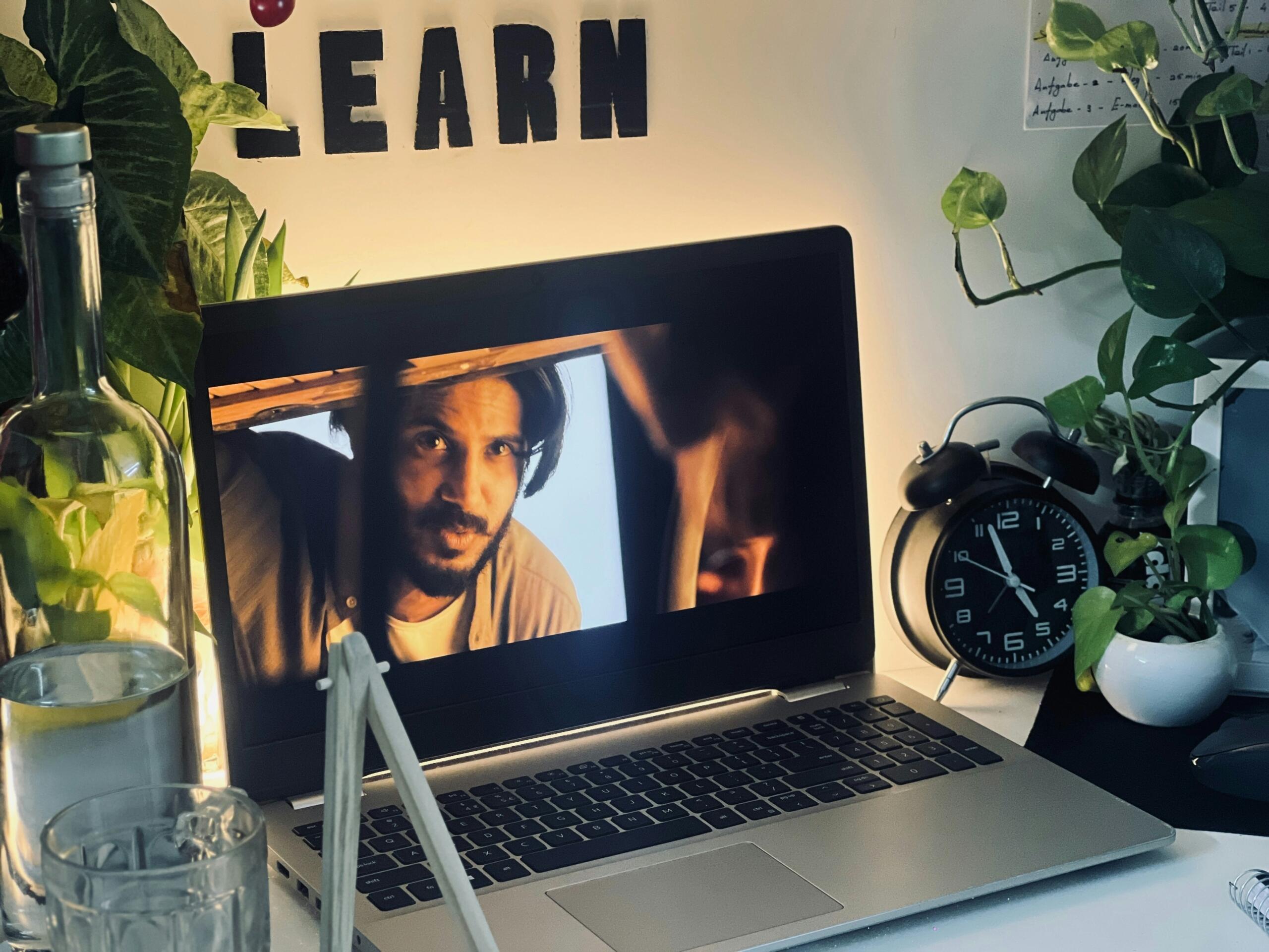 Prenosni računalnik na delovni mizi z napisom »Learn« v ozadju.