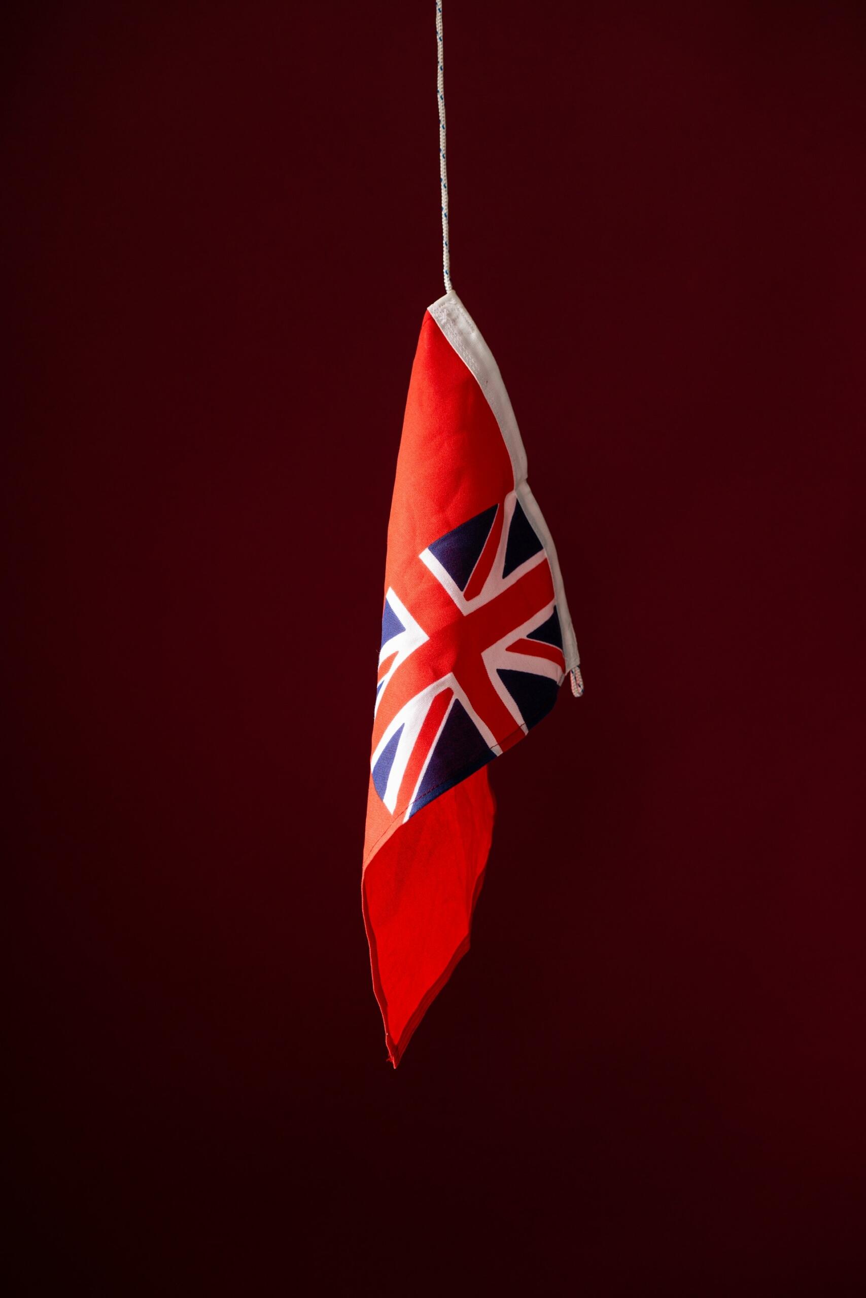 Britská vlajka visiaca na červenom pozadí