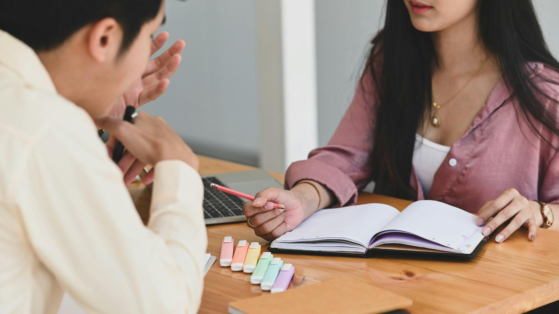 Individuálna konzultácia učiteľa so študentom pri zápisníku.