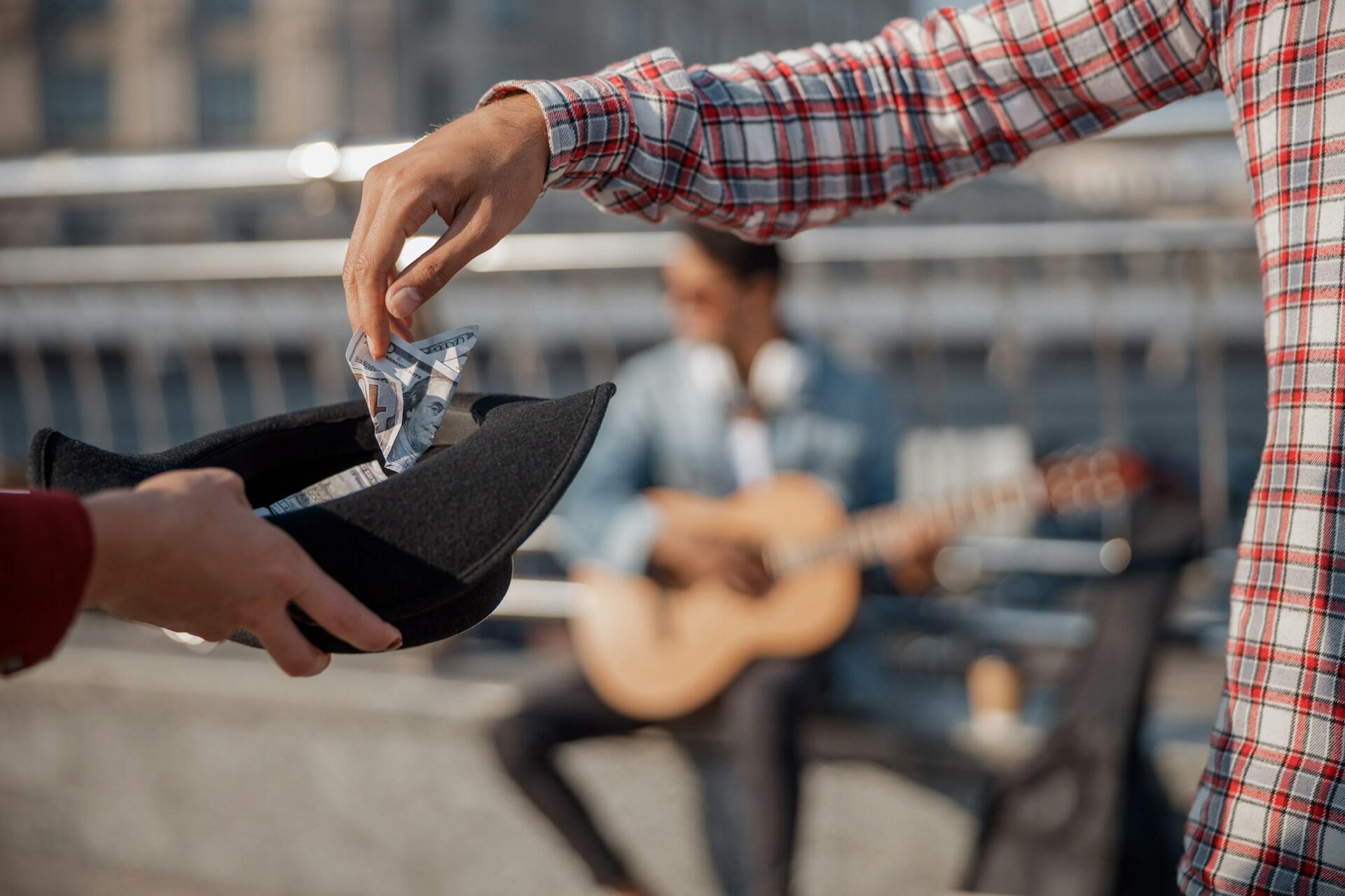 Pouličný gitarista zarábajúci peniaze hraním na gitare