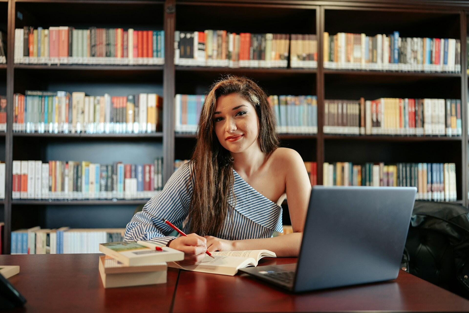 dievča sedí s otvoreným zošitom a učí sa