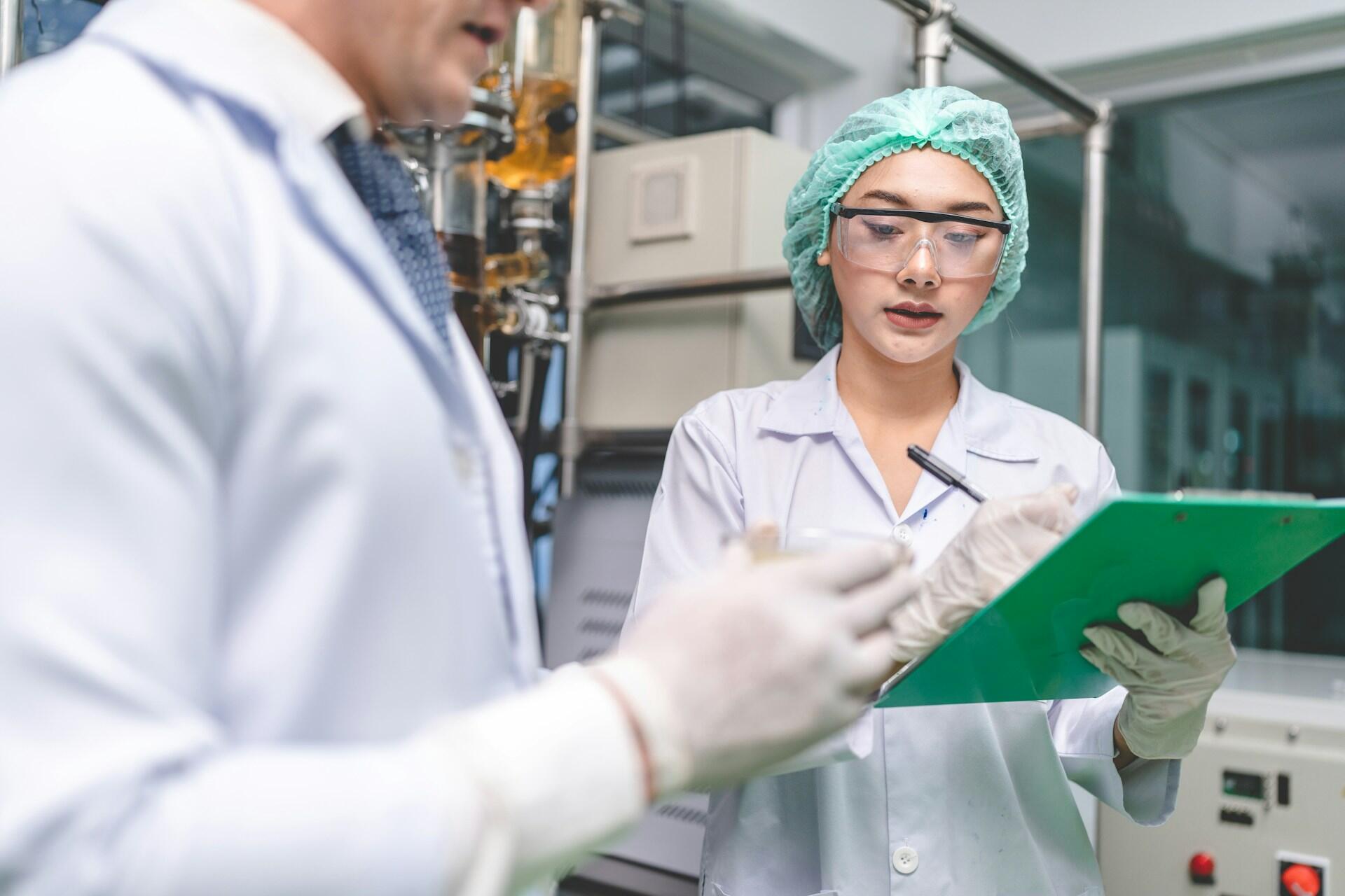 Vedci v laboratóriu zapisujú výsledky výskumu na clipboard