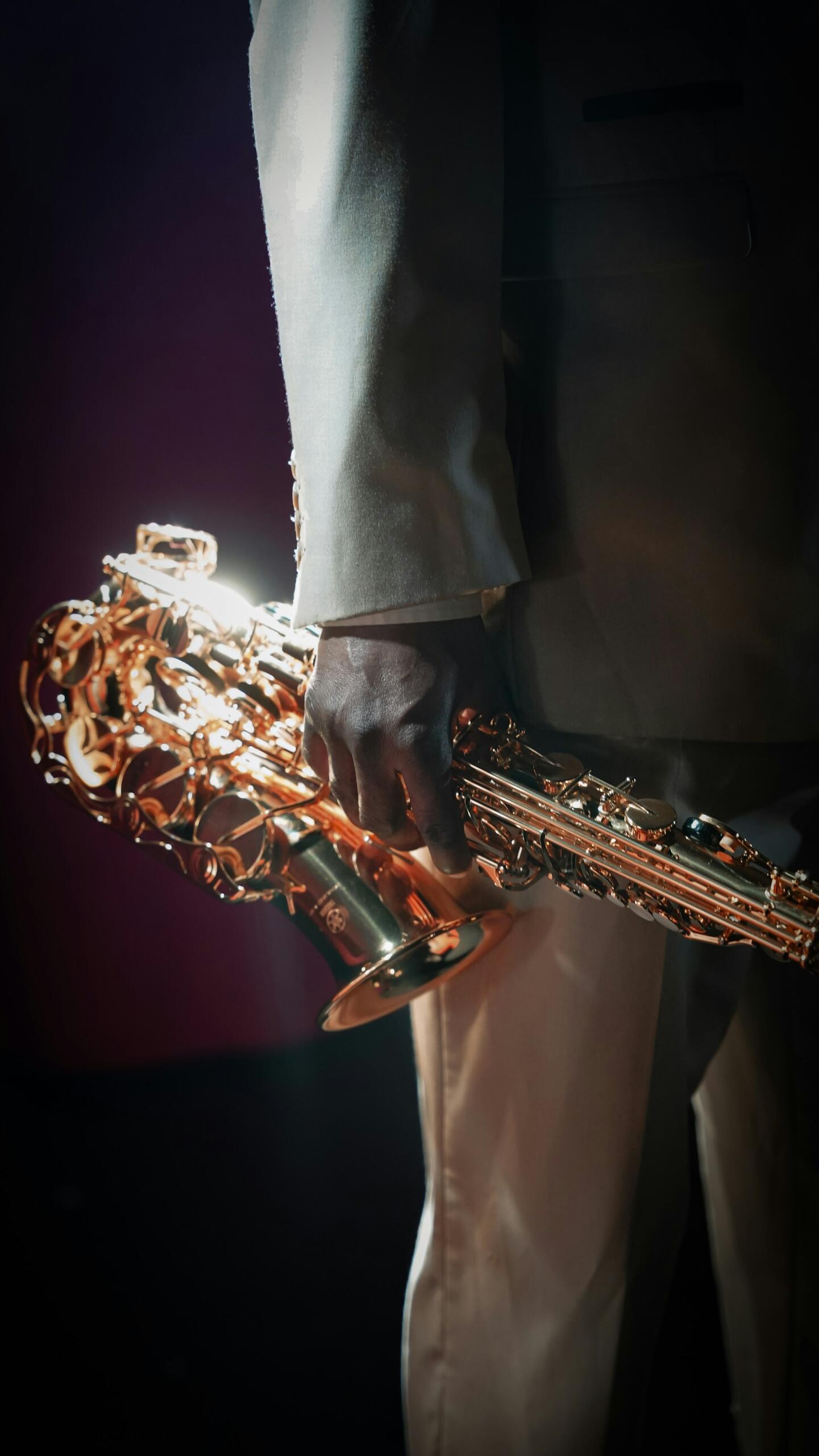 Hudobník drží saxofón pripravený na vystúpenie