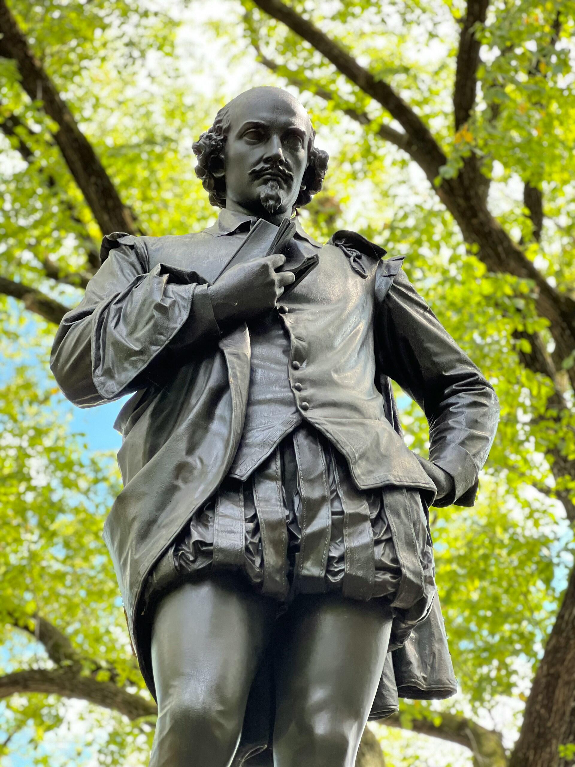 Socha Williama Shakespeara v parku medzi stromami