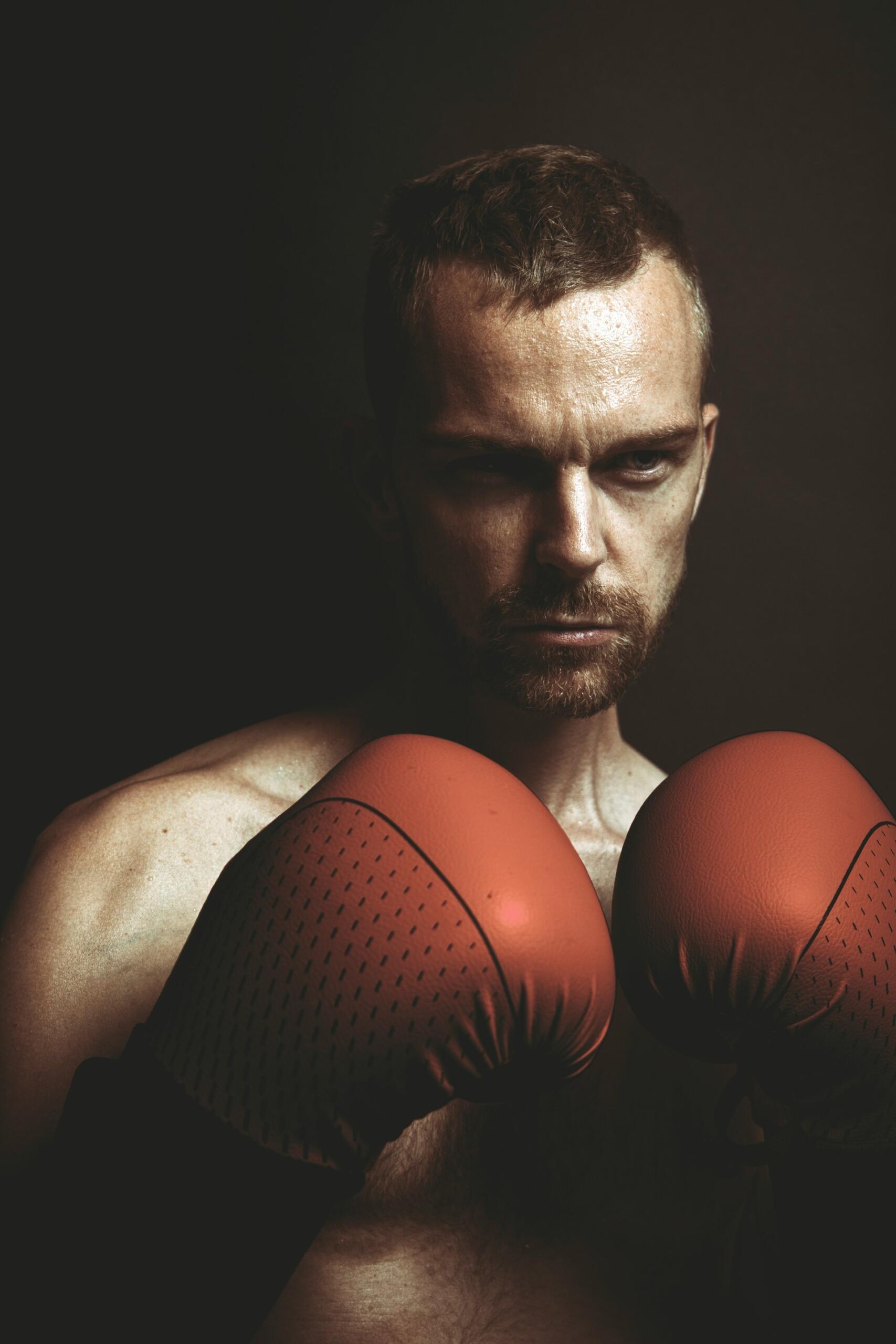 Sebavedomý boxer v rukaviciach pripravený na súboj v dramatickom osvetlení