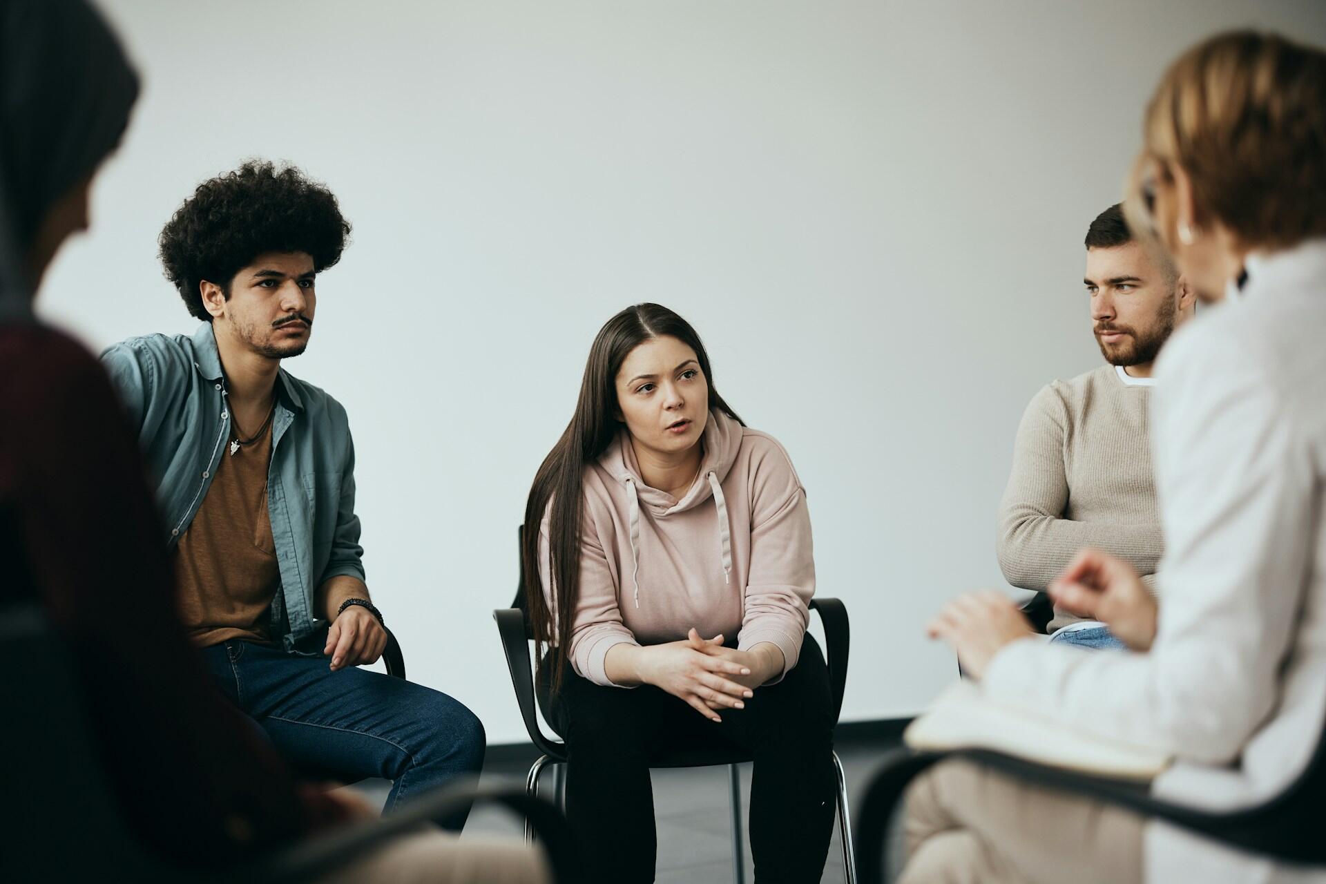 Skupina ľudí sediacich v kruhu počas diskusie, výučby alebo jazykového workshopu