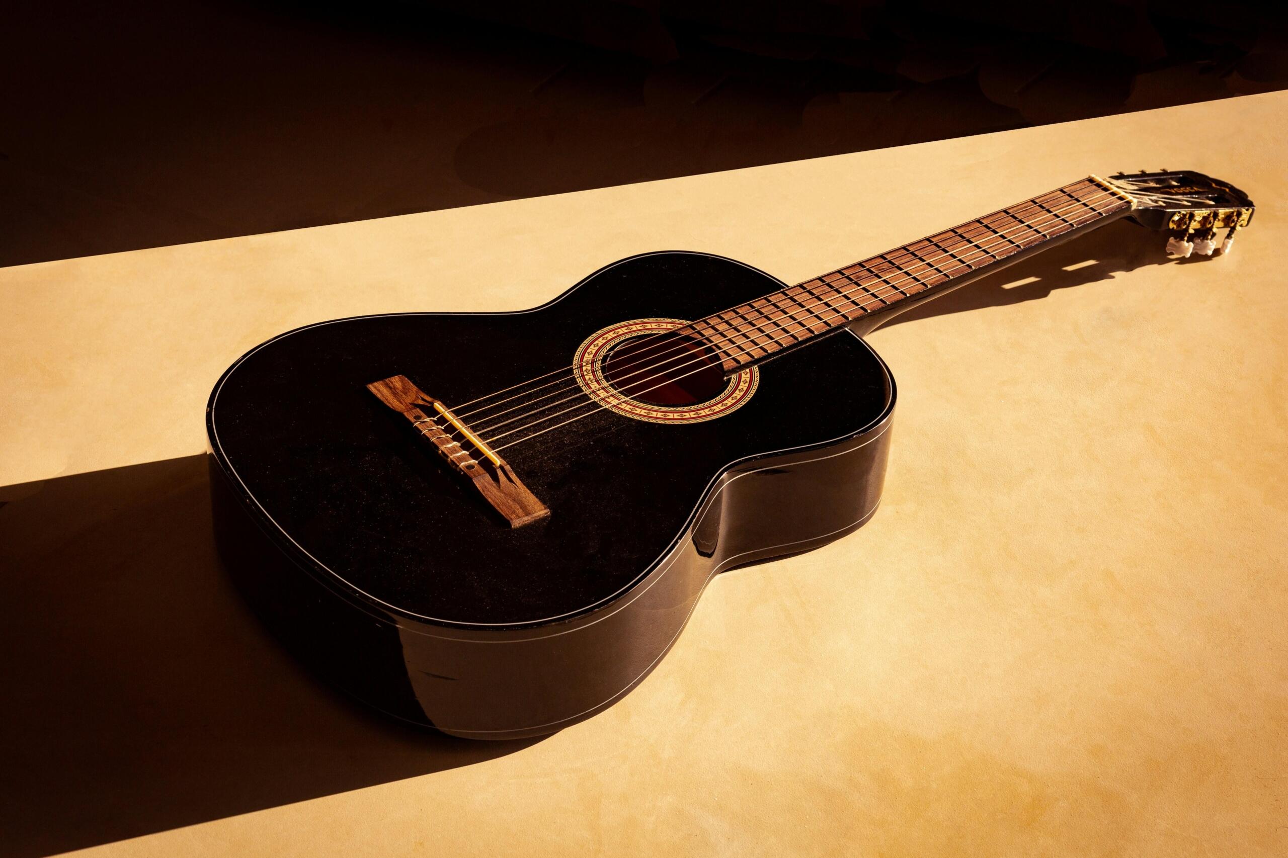 akustická gitara v teplých farbách vrhajúca tieň