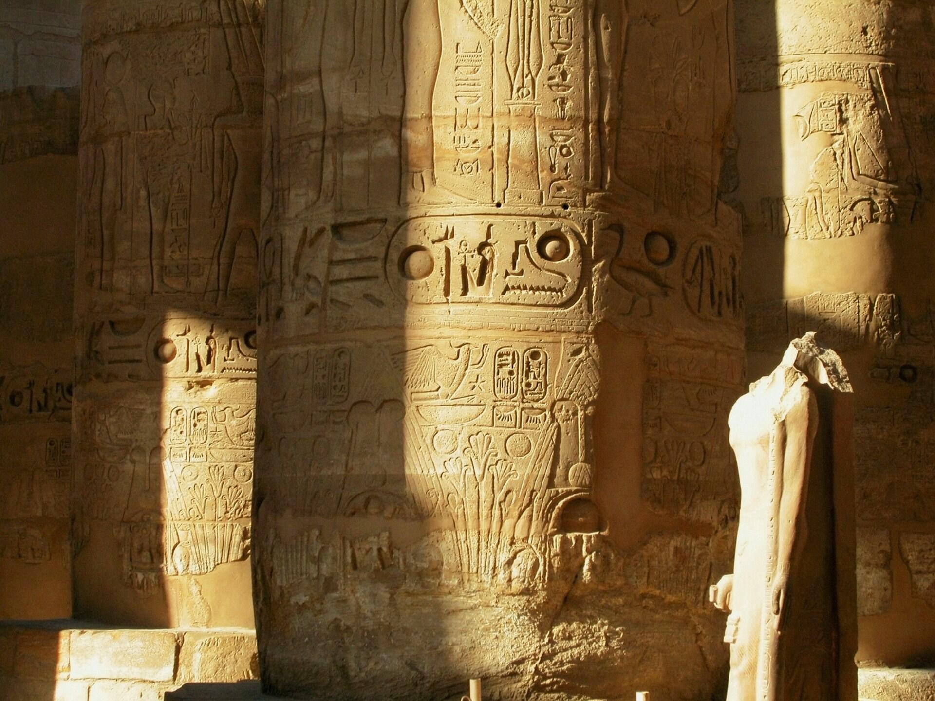 Staroveký egyptský chrám s hieroglyfmi vytesanými do kamenných stĺpov.