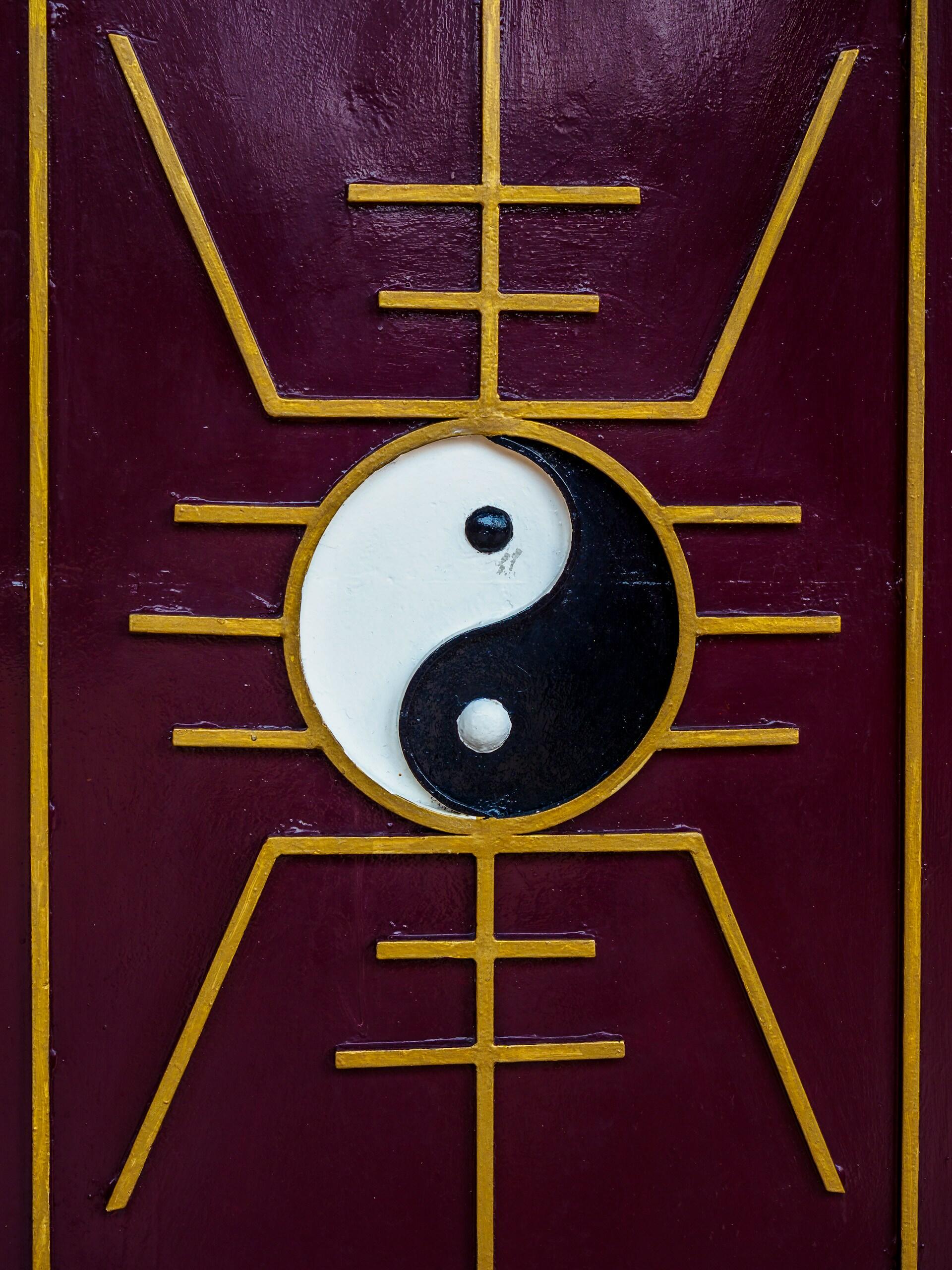 Tradičný symbol jin a jang v čierno-bielom prevedení so zlatými čínskymi motívmi.
