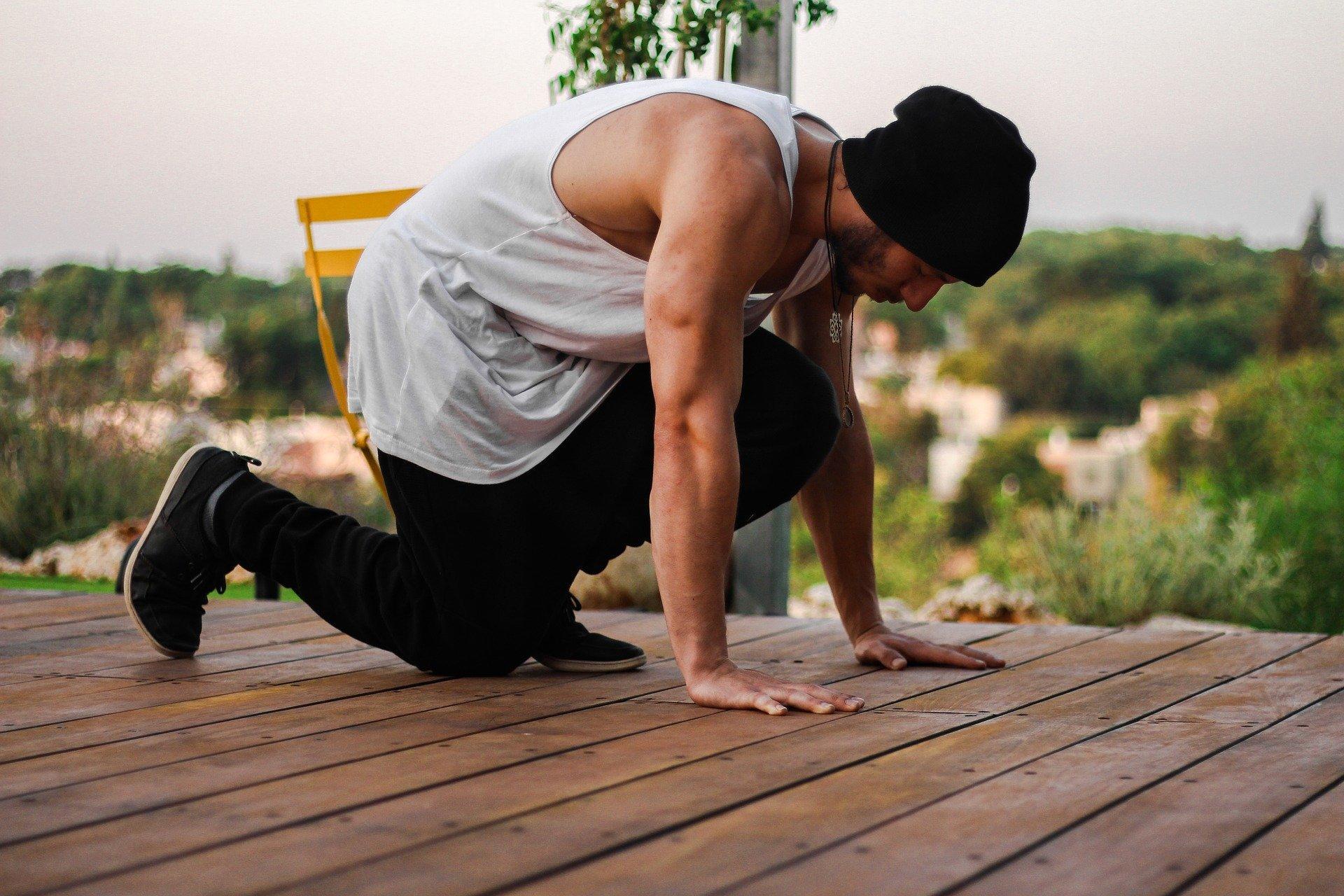 Siyah bereli beyaz atletli sporcu antrenmanda.