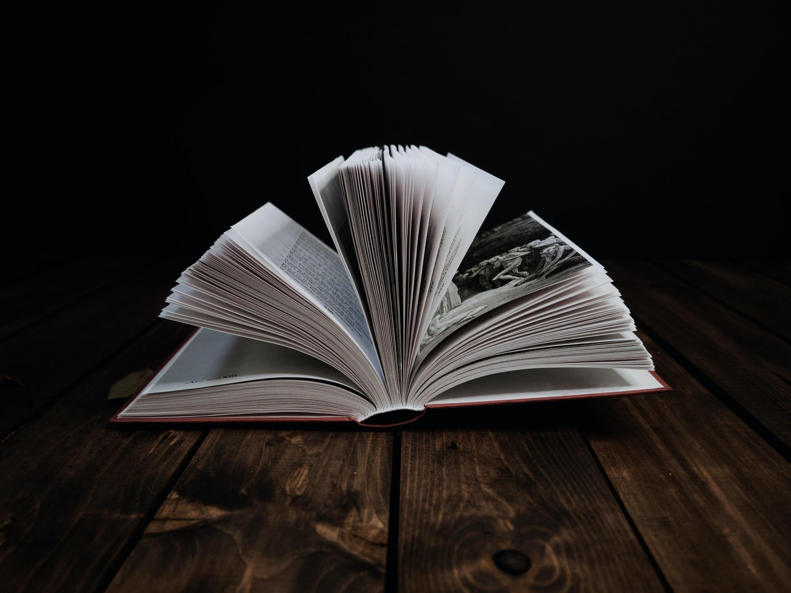 Masanın üstünde sayfaları açılmış kitap