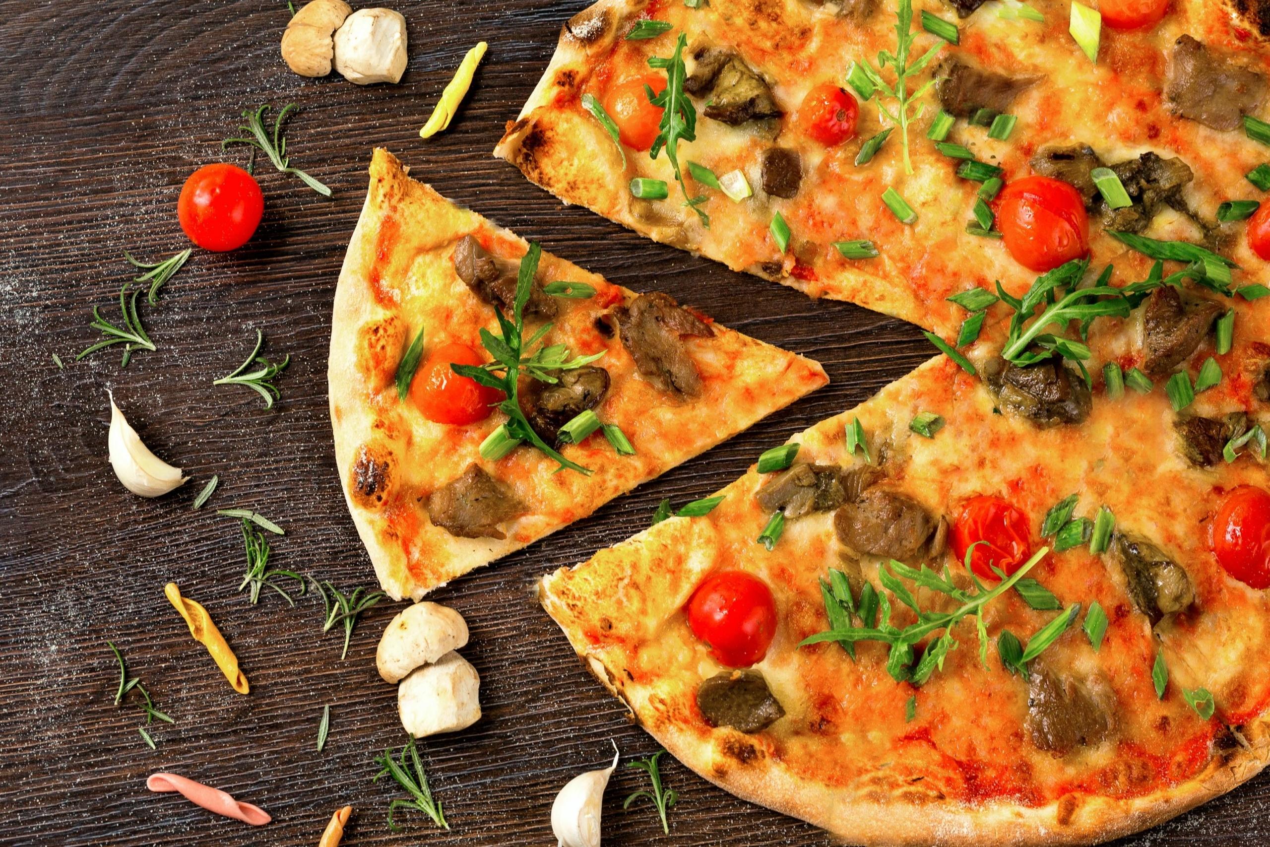 Bir dilimi kesilmiş sebzeli pizza