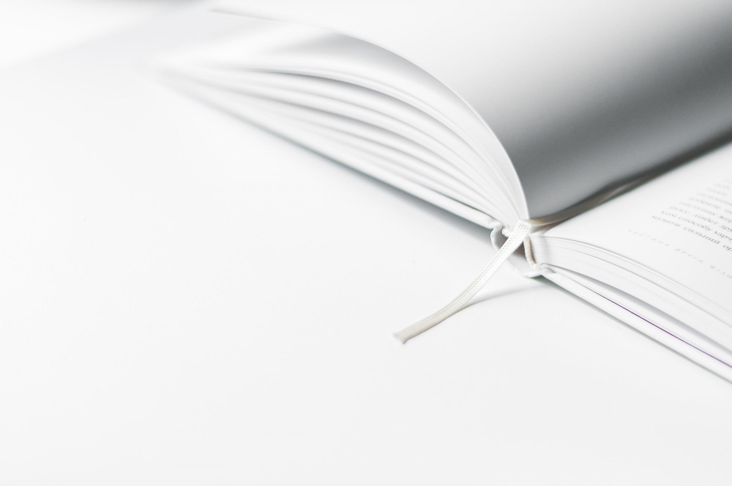Beyaz zemin üstünde beyaz sayfalı açık kitap