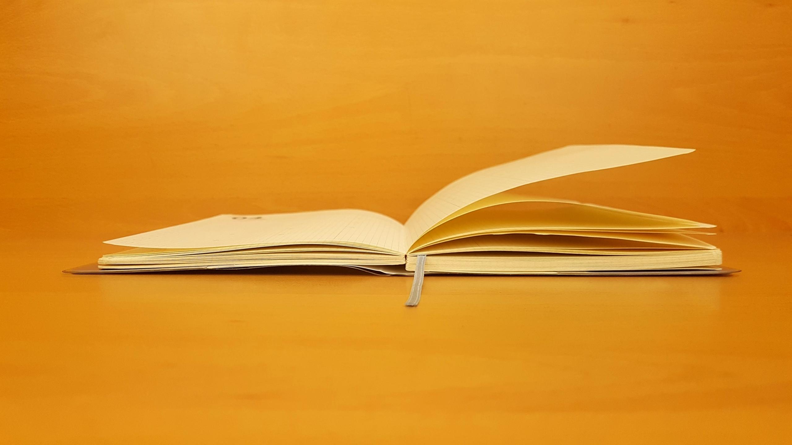Turuncu arka planda açık kitap sayfaları