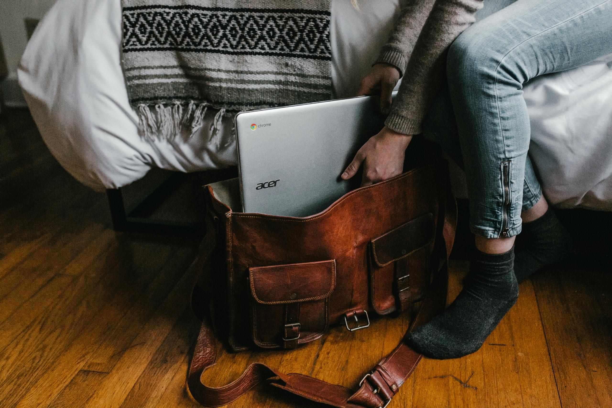 Çantaya laptop koyan adam