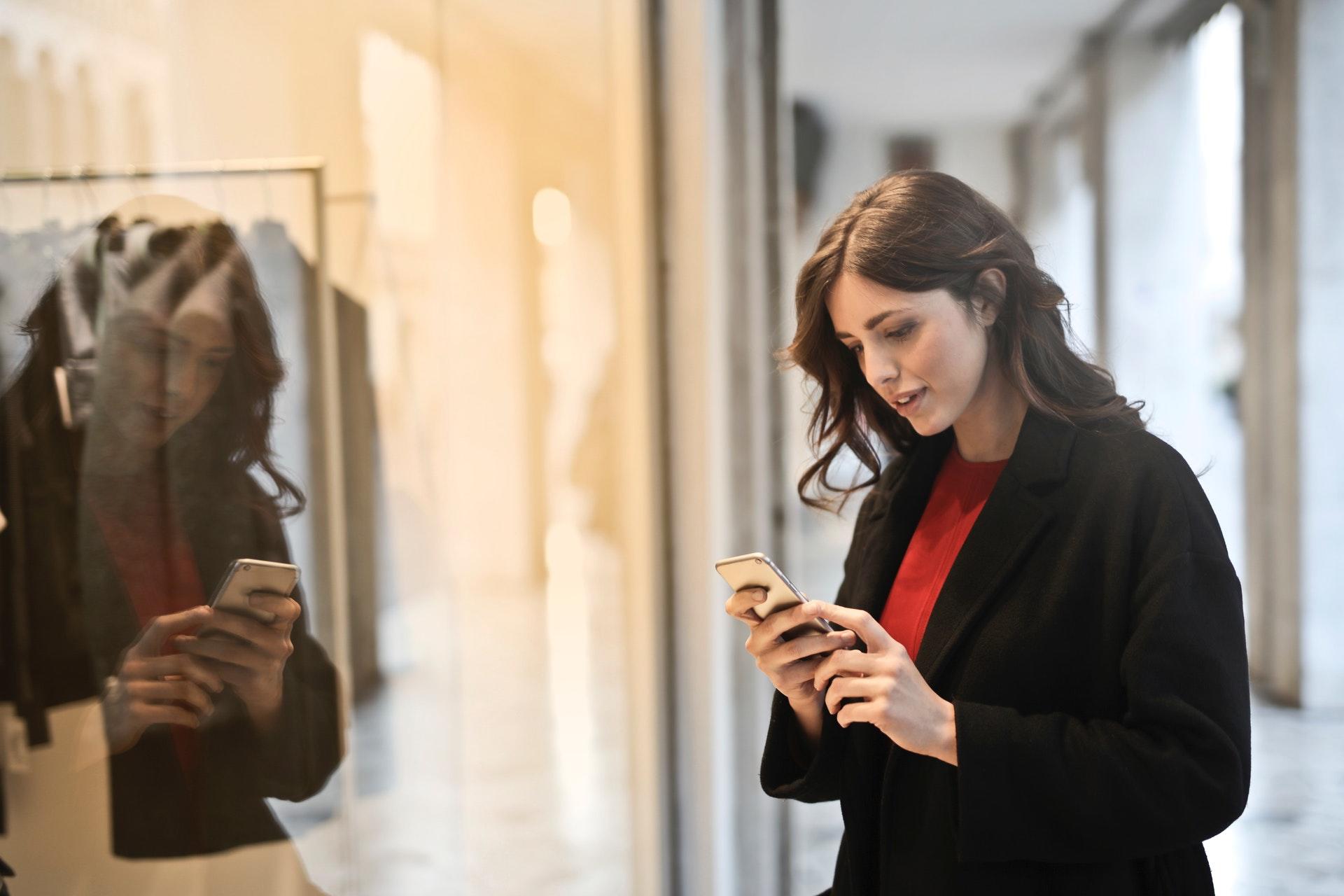 Telefonuna bakan kırmızı kazaklı kadın