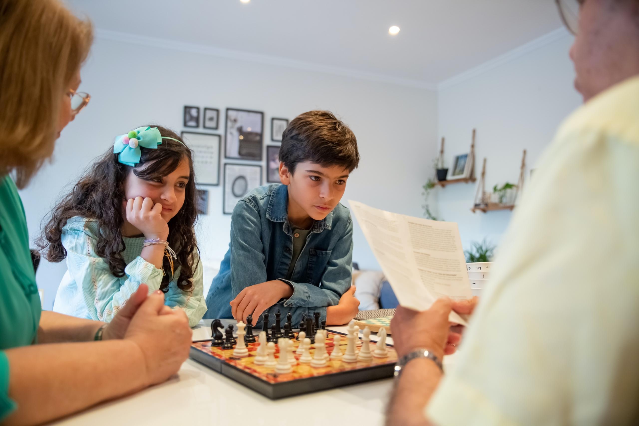 Adamla satranç oynayan kız ve erkek çocuk