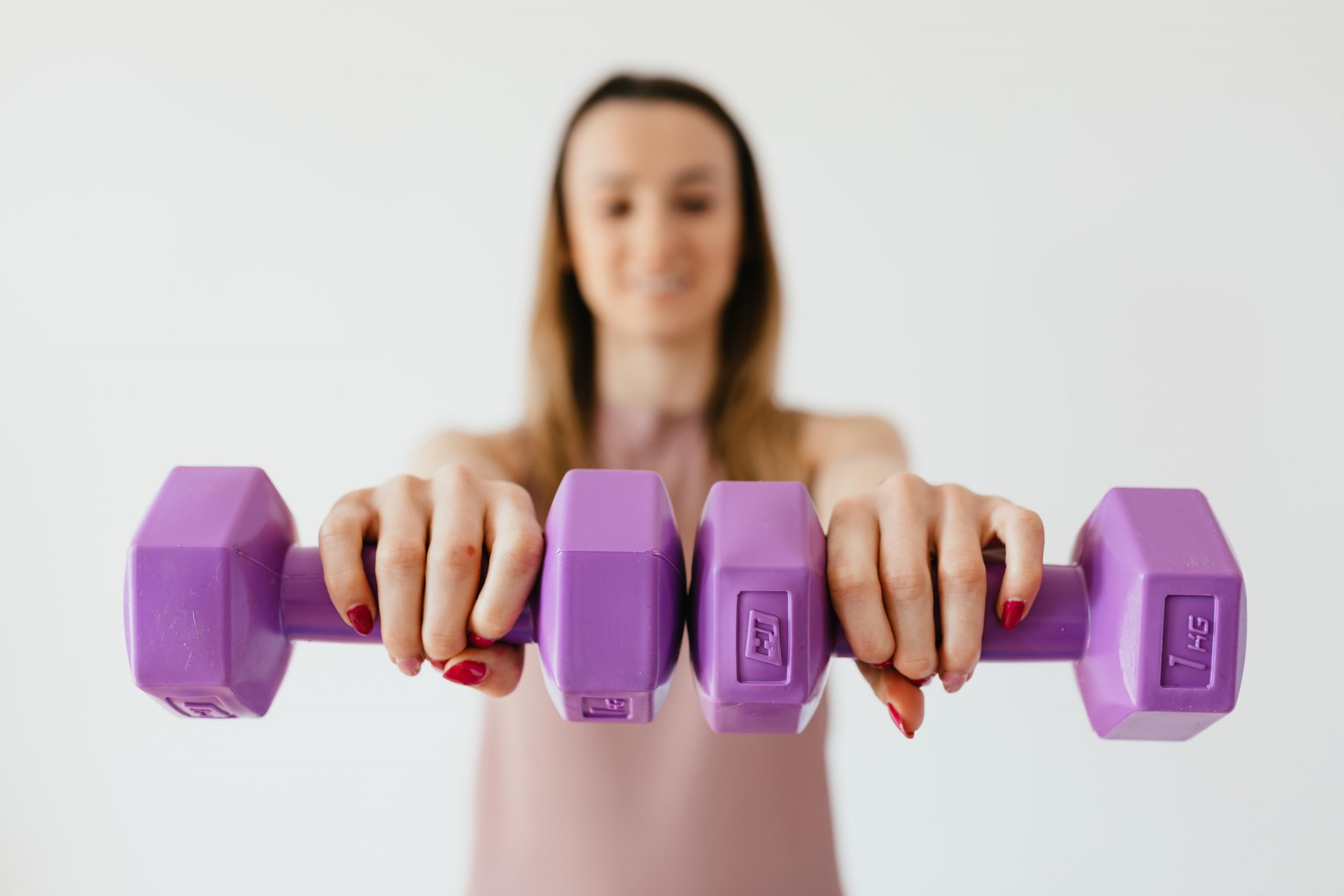 Elinde mor dumbbell tutan kadın