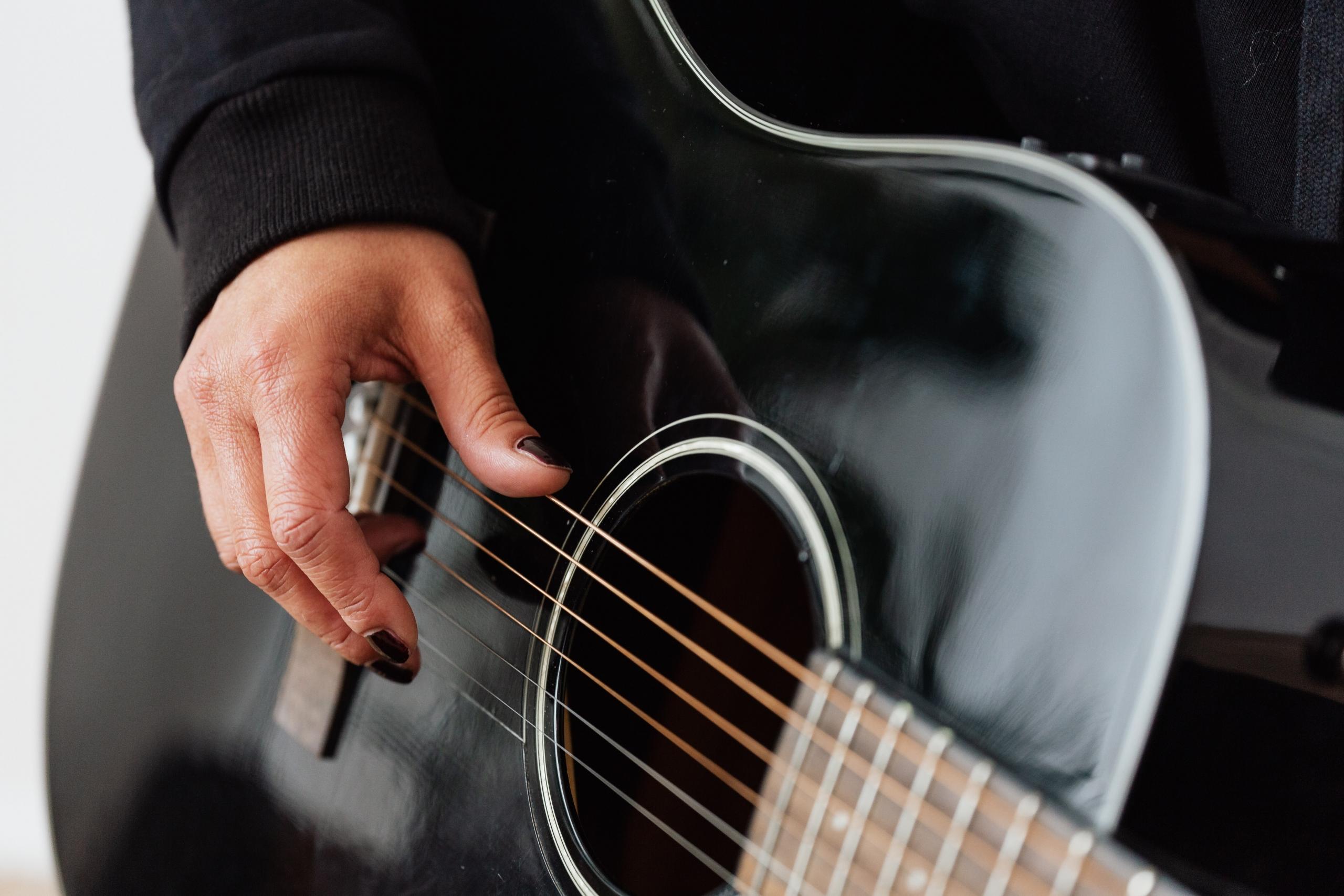 Siyah klasik gitarda siyah ojeli parmaklar