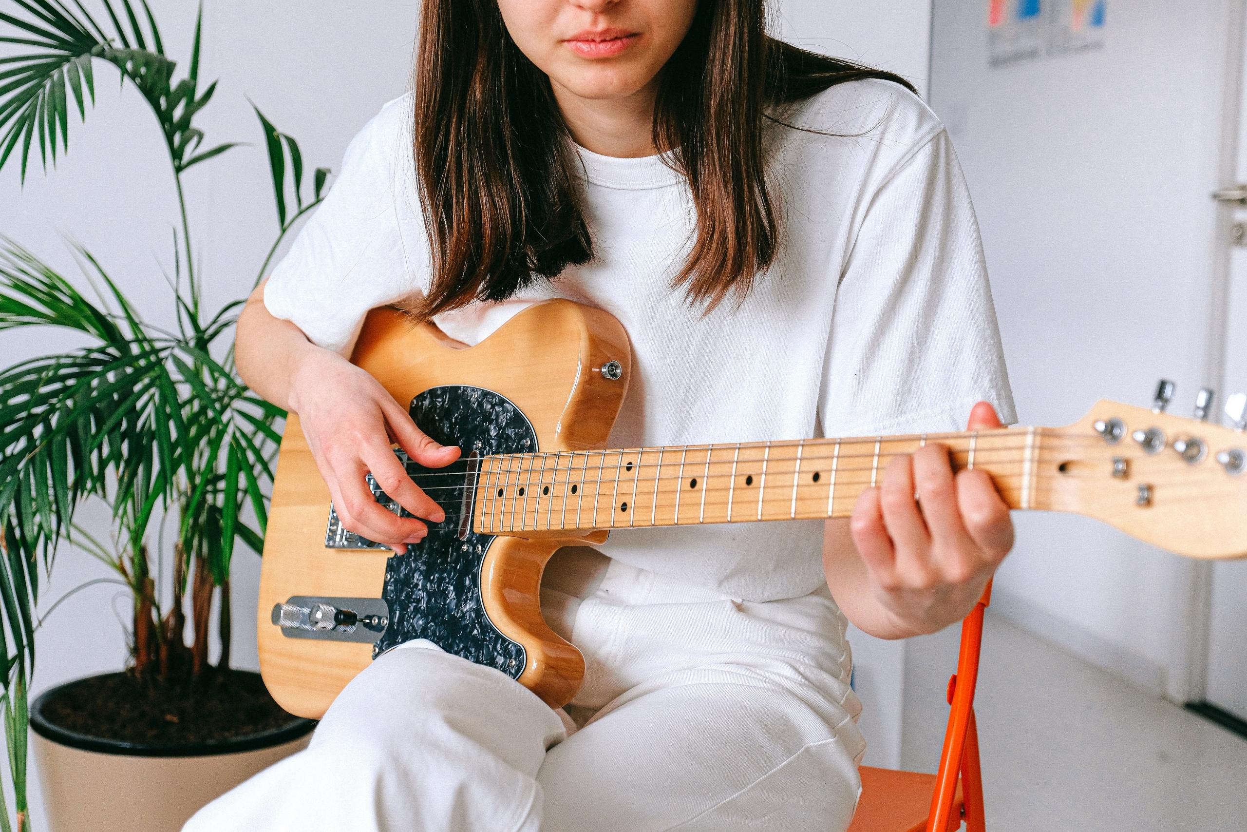 Elektro gitar çalan beyaz tişörtlü kız
