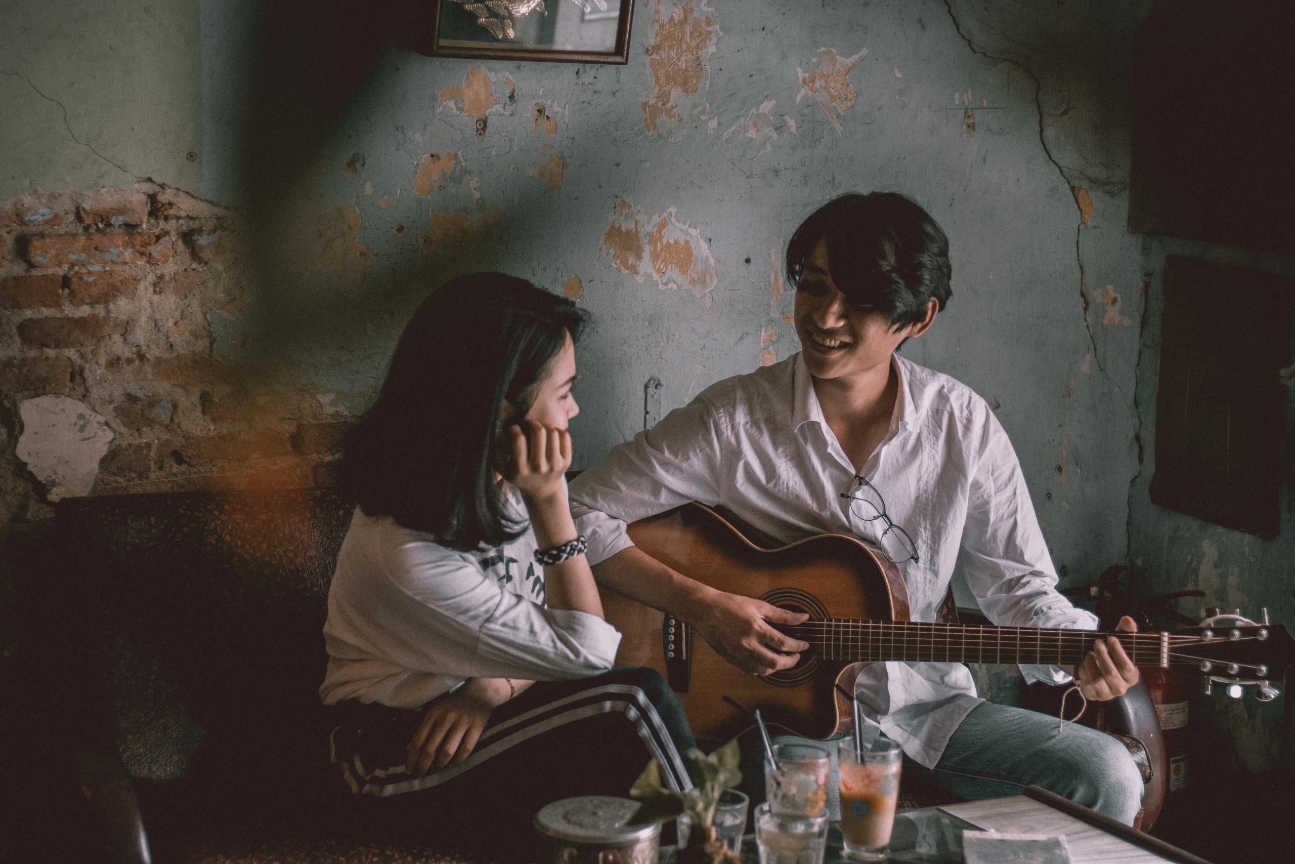 Odada gitar çalan adama bakan kadın