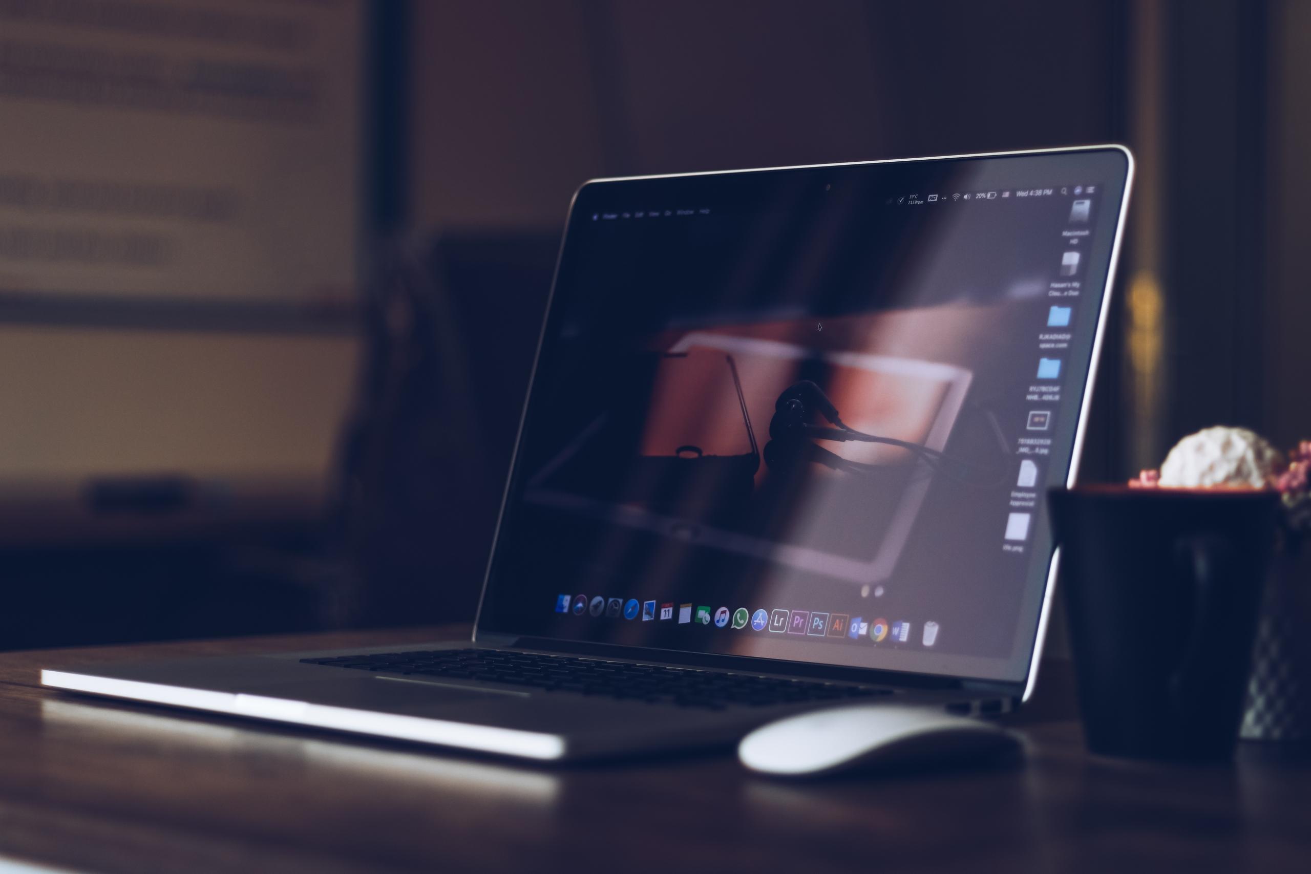 Masanın üstünde açık laptop ve fare