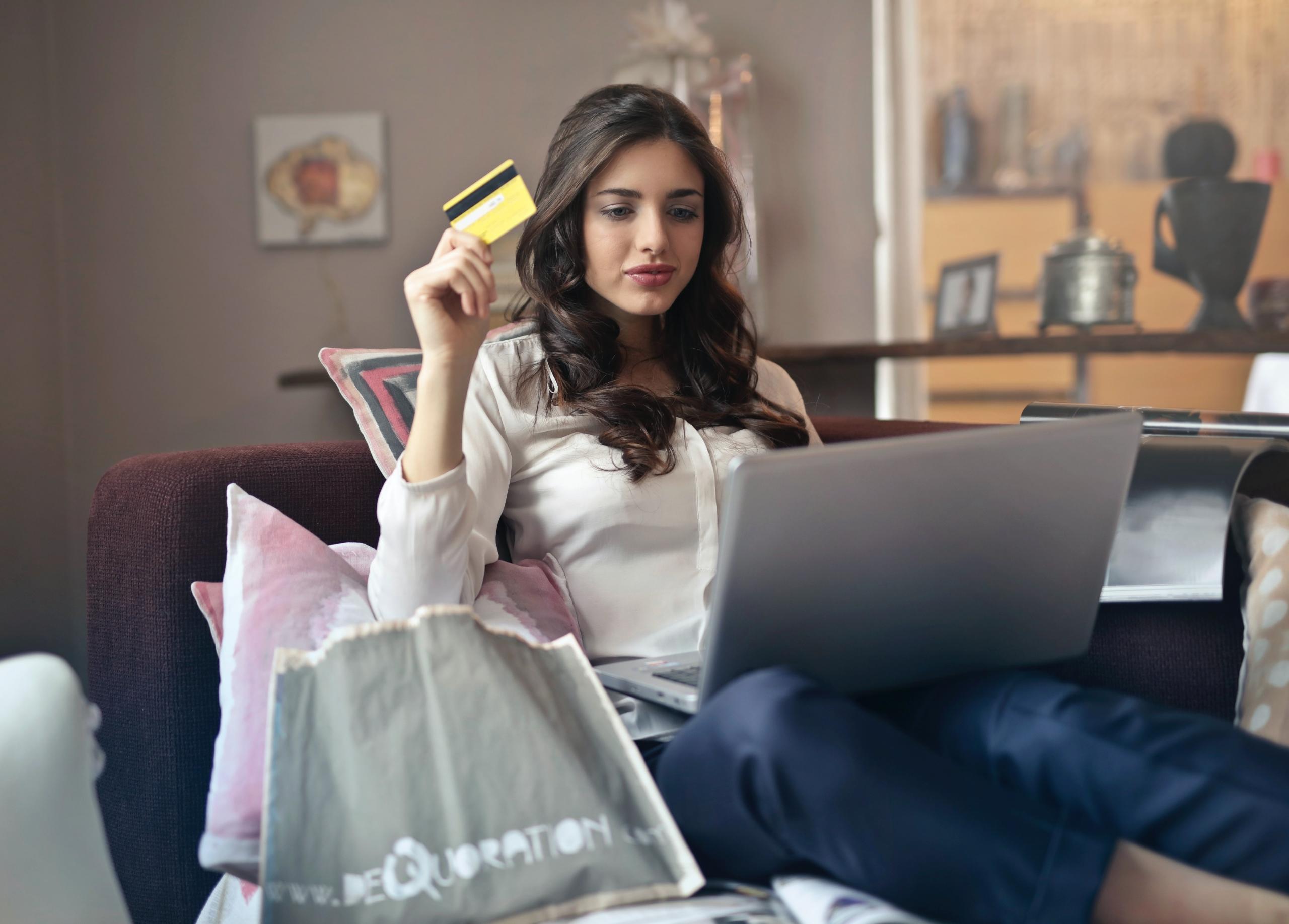 Elinde kart tutan kucağında laptop olan kadın