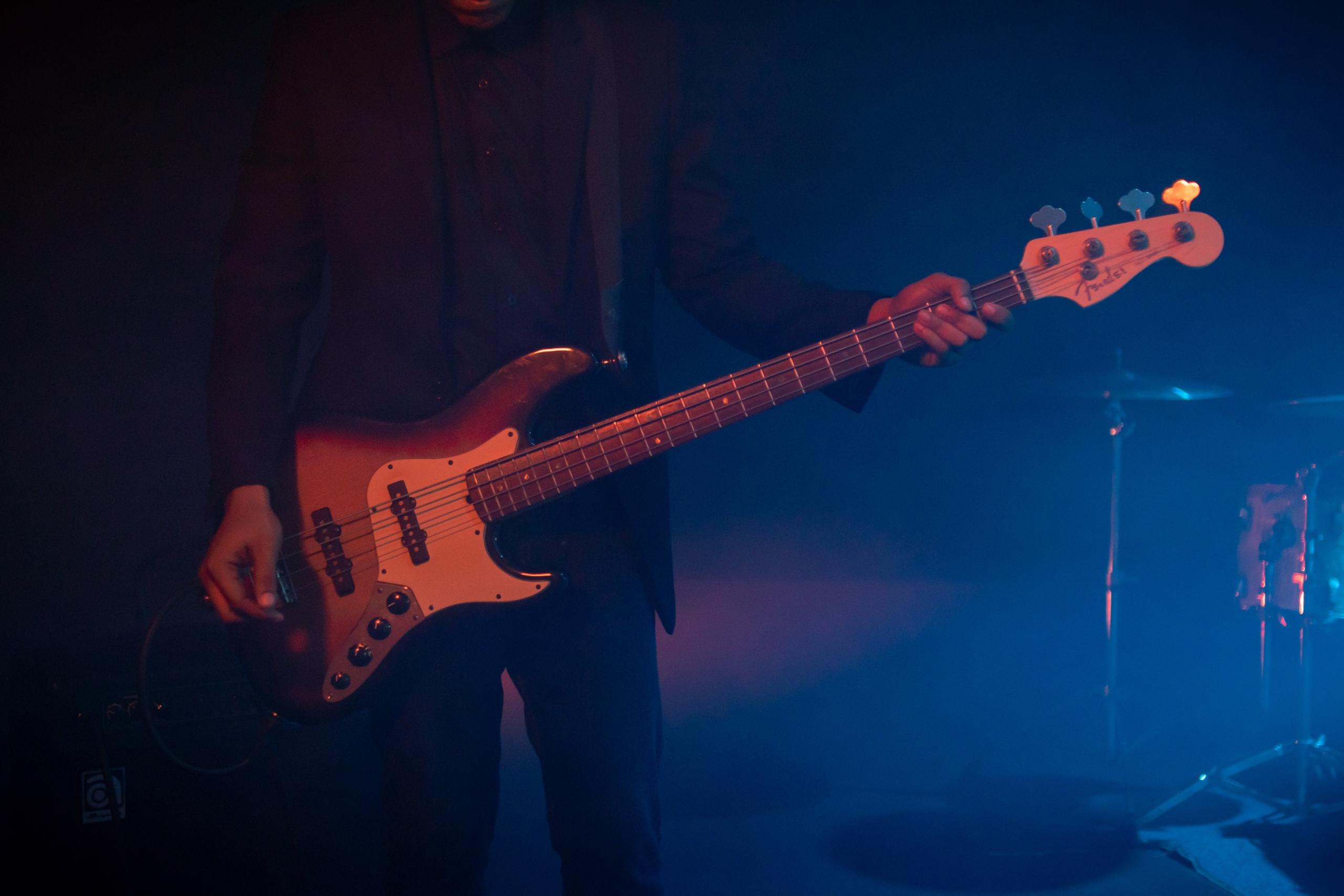 Konserde bas gitar çalan insan