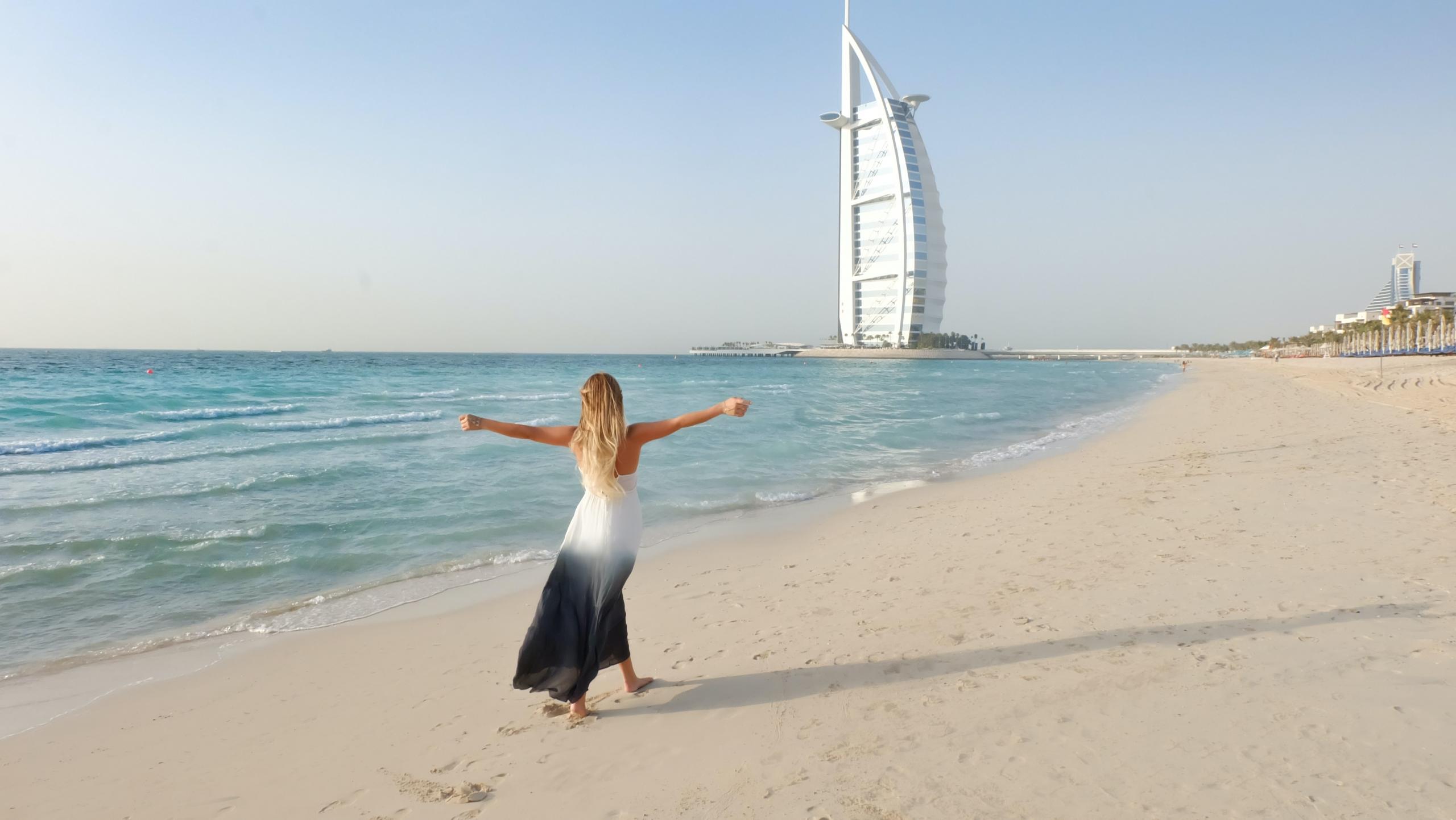 Dubai sahil kenarında kollarını açmış kadın