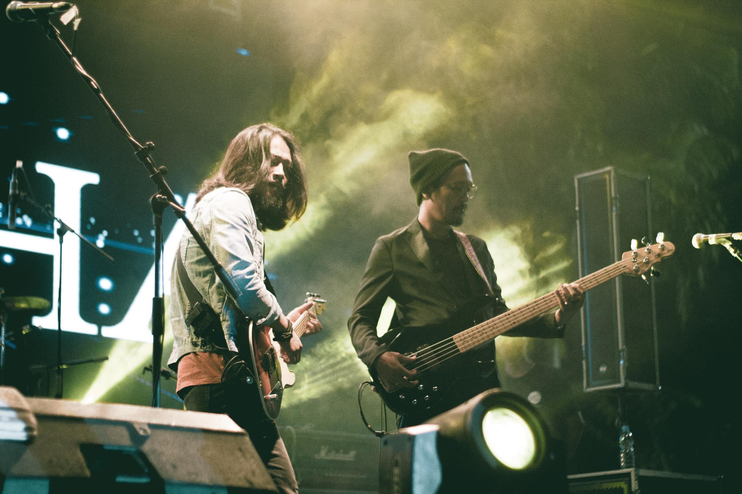 Konserde gitar çalan iki erkek