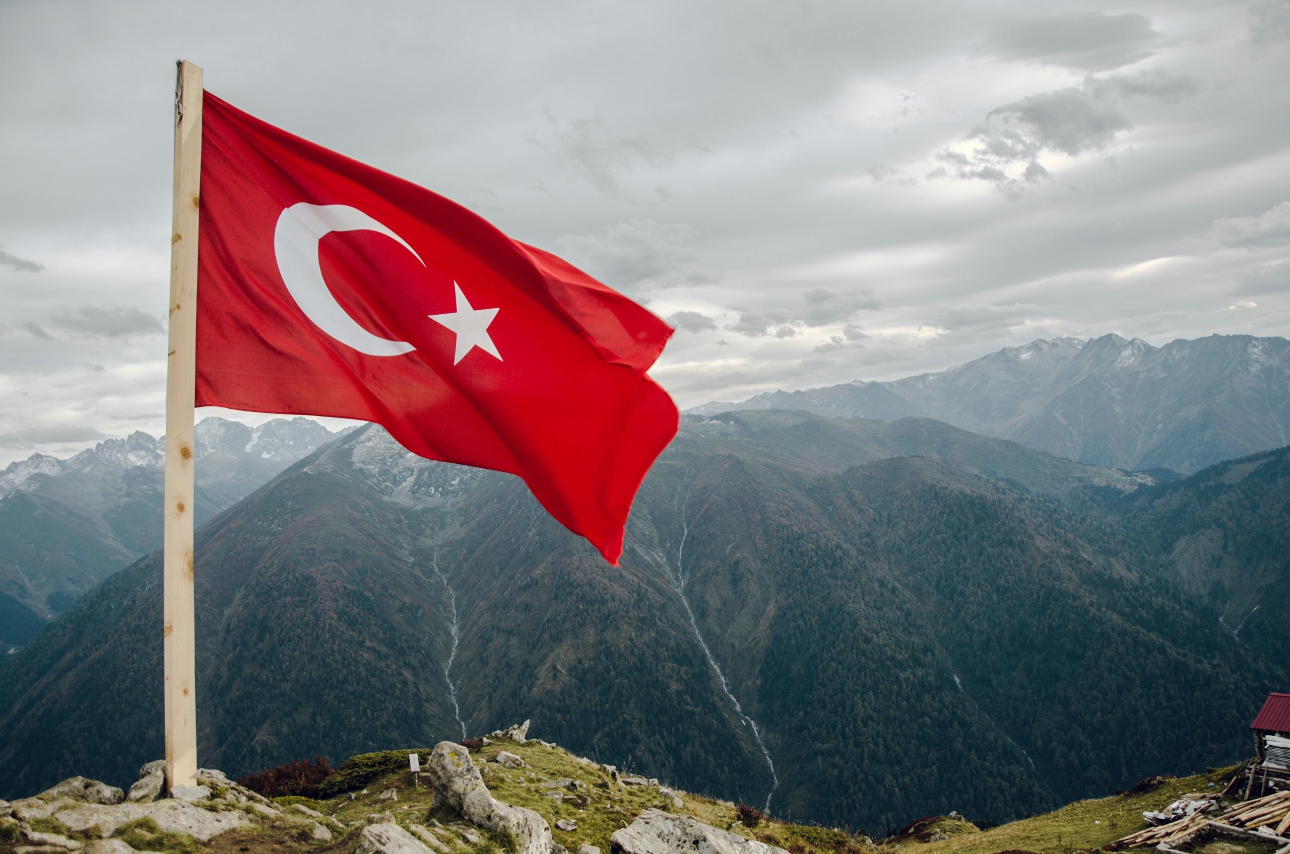 Dağların tepesinde dalgalanan Türkiye bayrağı