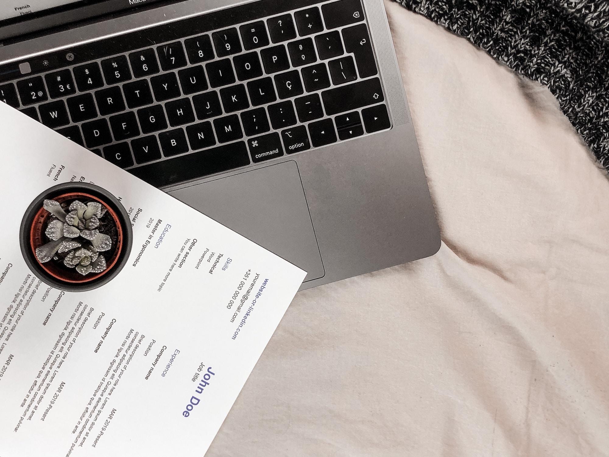 Laptop üstünde duran öz geçmiş belgesi