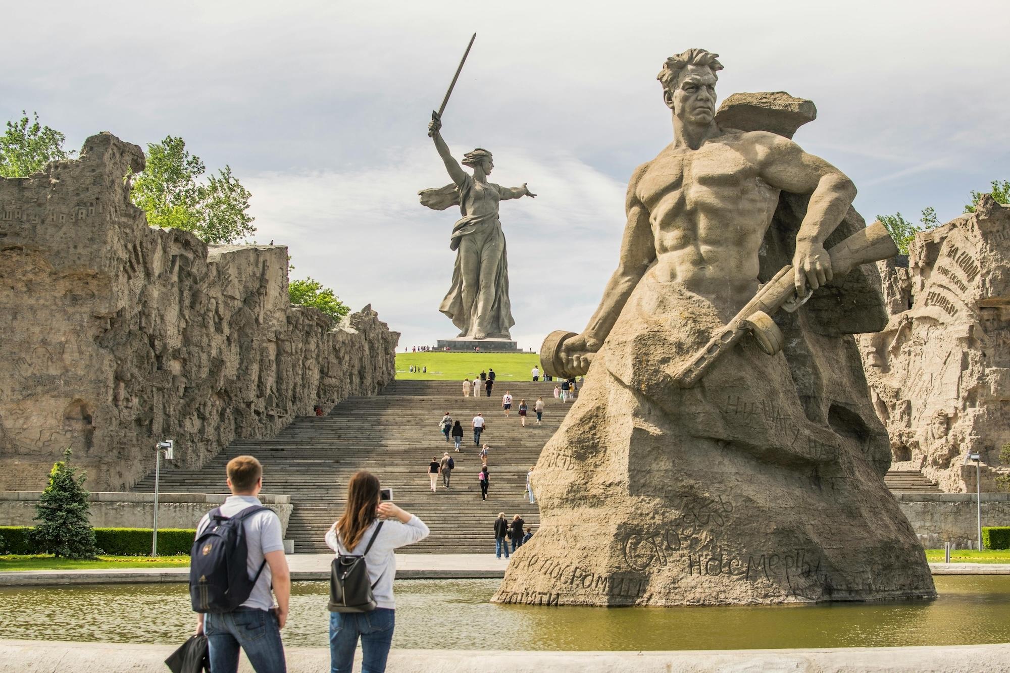 İki heykelin önünde gezen insanlar
