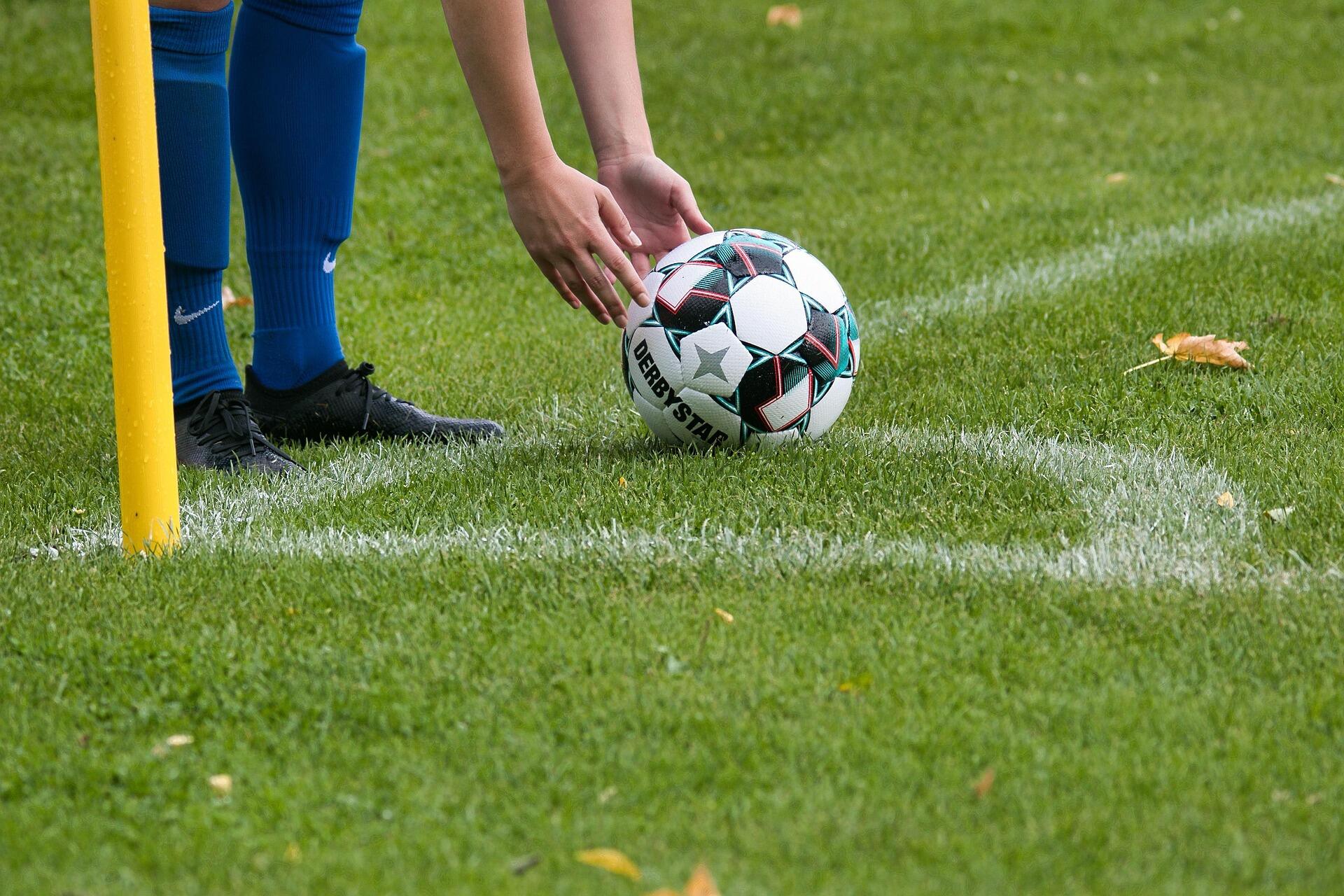 Korner noktasına topu yerleştiren bir futbolcu